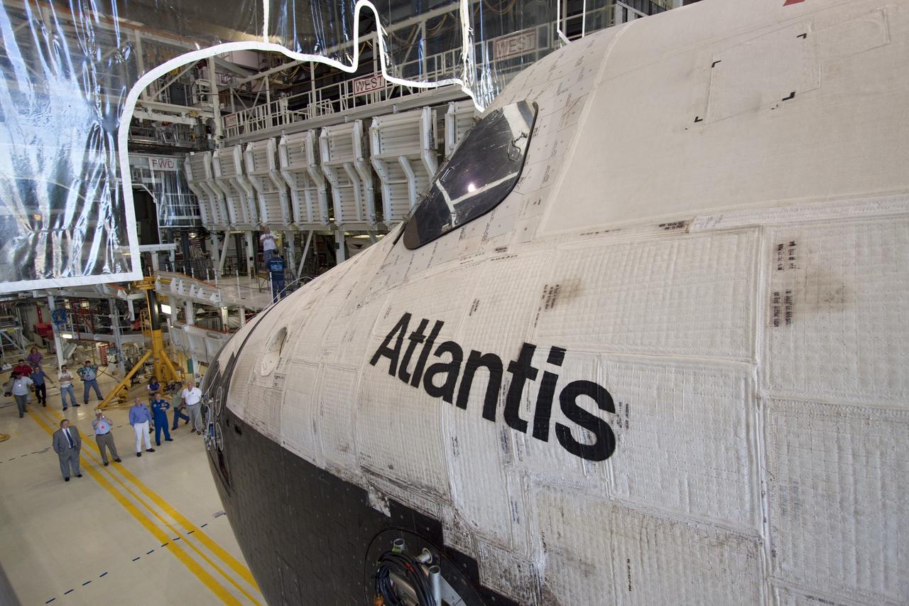 CAPE CANAVERAL, Fla. -- Workers watch as shuttle Atlantis slowly backs out of Orbiter Processing Facility-1 during its final planned move to the Vehicle Assembly Building at NASA's Kennedy Space Center in Florida. The move called "rollover" is a major milestone in processing for the STS-135 mission to the International Space Station. Inside the VAB, the shuttle will be attached to its external fuel tank and solid rocket boosters. Commander Chris Ferguson, Pilot Doug Hurley and Mission Specialists Sandra Magnus and Rex Walheim are targeted to launch in early July, taking with them the Raffaello multipurpose logistics module packed with supplies, logistics and spare parts. The STS-135 mission also will fly a system to investigate the potential for robotically refueling existing spacecraft and return a failed ammonia pump module to help NASA better understand the failure mechanism and improve pump designs for future systems.        STS-135 will be the 33rd flight of Atlantis, the 37th shuttle mission to the space station, and the 135th and final mission of NASA's Space Shuttle Program. For more information visit, www.nasa.gov/mission_pages/shuttle/shuttlemissions/sts135/index.html. Photo credit: NASA/Jack Pfaller