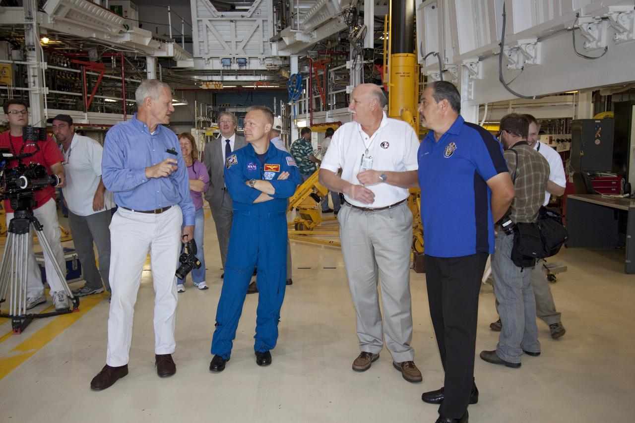 CAPE CANAVERAL, Fla. -- STS-135 Pilot Doug Hurley talks with workers in Orbiter Processing Facility-1 during shuttle Atlantis' final planned move to the Vehicle Assembly Building at NASA's Kennedy Space Center in Florida. The move called "rollover" is a major milestone in processing for the STS-135 mission to the International Space Station. Inside the VAB, the shuttle will be attached to its external fuel tank and solid rocket boosters. Hurley, along with Commander Chris Ferguson, and Mission Specialists Rex Walheim and Sandra Magnus are targeted to launch in early July, taking with them the Raffaello multipurpose logistics module packed with supplies, logistics and spare parts. The STS-135 mission also will fly a system to investigate the potential for robotically refueling existing spacecraft and return a failed ammonia pump module to help NASA better understand the failure mechanism and improve pump designs for future systems.      STS-135 will be the 33rd flight of Atlantis, the 37th shuttle mission to the space station, and the 135th and final mission of NASA's Space Shuttle Program. For more information visit, www.nasa.gov/mission_pages/shuttle/shuttlemissions/sts135/index.html. Photo credit: NASA/Jack Pfaller