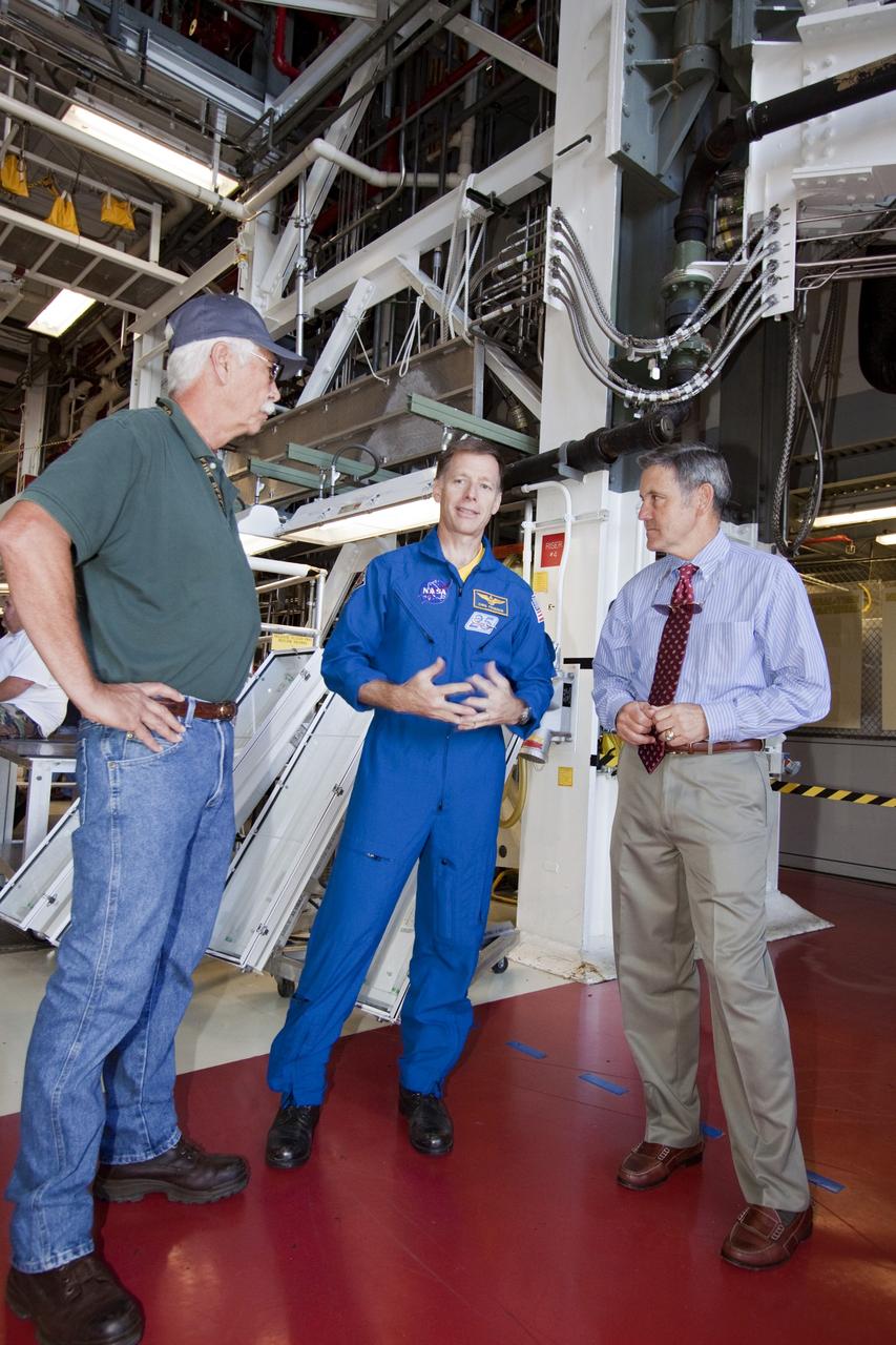 CAPE CANAVERAL, Fla. -- STS-135 Commander Chris Ferguson talks with United Space Alliance tile technician Terry White, left, and NASA Kennedy Space Center Director Bob Cabana, right, in Orbiter Processing Facility-1 during shuttle Atlantis' final planned move to the Vehicle Assembly Building. The move called "rollover" is a major milestone in processing for the STS-135 mission to the International Space Station. Inside the VAB, the shuttle will be attached to its external fuel tank and solid rocket boosters. Ferguson, along with Pilot Doug Hurley and Mission Specialists Rex Walheim and Sandra Magnus are targeted to launch in early July, taking with them the Raffaello multipurpose logistics module packed with supplies, logistics and spare parts. The STS-135 mission also will fly a system to investigate the potential for robotically refueling existing spacecraft and return a failed ammonia pump module to help NASA better understand the failure mechanism and improve pump designs for future systems.          STS-135 will be the 33rd flight of Atlantis, the 37th shuttle mission to the space station, and the 135th and final mission of NASA's Space Shuttle Program. For more information visit, www.nasa.gov/mission_pages/shuttle/shuttlemissions/sts135/index.html. Photo credit: NASA/Jack Pfaller