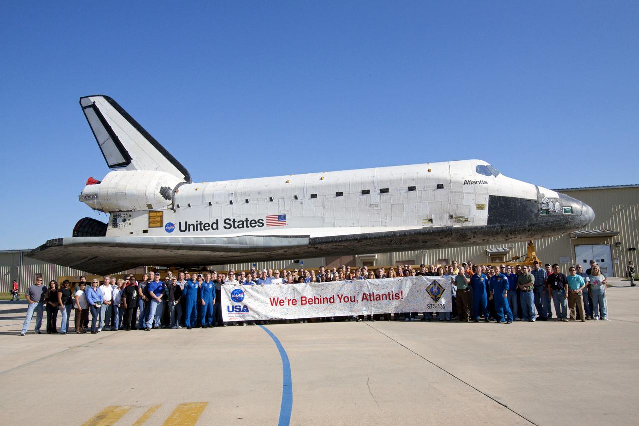 CAPE CANAVERAL, Fla. -- Workers and the crew of STS-135 hold up a "We're Behind You, Atlantis" banner during the final planned move of shuttle Atlantis from Orbiter Processing Facility-1 to the Vehicle Assembly Building at NASA's Kennedy Space Center in Florida. The move called "rollover" is a major milestone in processing for the STS-135 mission to the International Space Station. Inside the VAB, the shuttle will be attached to its external fuel tank and solid rocket boosters. Commander Chris Ferguson, Pilot Doug Hurley and Mission Specialists Sandra Magnus and Rex Walheim are targeted to launch in early July, taking with them the Raffaello multipurpose logistics module packed with supplies, logistics and spare parts. The STS-135 mission also will fly a system to investigate the potential for robotically refueling existing spacecraft and return a failed ammonia pump module to help NASA better understand the failure mechanism and improve pump designs for future systems.        STS-135 will be the 33rd flight of Atlantis, the 37th shuttle mission to the space station, and the 135th and final mission of NASA's Space Shuttle Program. For more information visit, www.nasa.gov/mission_pages/shuttle/shuttlemissions/sts135/index.html. Photo credit: NASA/Jack Pfaller