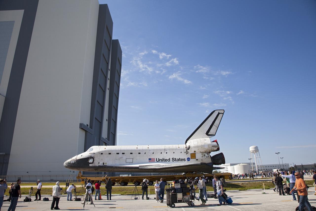 CAPE CANAVERAL, Fla. -- Shuttle Atlantis is parked in front of the Vehicle Assembly Building (VAB) at NASA's Kennedy Space Center in Florida as media and Kennedy employees snap photos before it is moved inside.          The move called "rollover" is a major milestone in processing for the STS-135 mission to the International Space Station. Inside the VAB, the shuttle will be attached to its external fuel tank and solid rocket boosters. Commander Chris Ferguson, Pilot Doug Hurley and Mission Specialists Sandra Magnus and Rex Walheim are targeted to launch in early July, taking with them the Raffaello multipurpose logistics module packed with supplies, logistics and spare parts. The STS-135 mission also will fly a system to investigate the potential for robotically refueling existing spacecraft and return a failed ammonia pump module to help NASA better understand the failure mechanism and improve pump designs for future systems. STS-135 will be the 33rd flight of Atlantis, the 37th shuttle mission to the space station, and the 135th and final mission of NASA's Space Shuttle Program. For more information visit, www.nasa.gov/mission_pages/shuttle/shuttlemissions/sts135/index.html. Photo credit: NASA/Frankie Martin