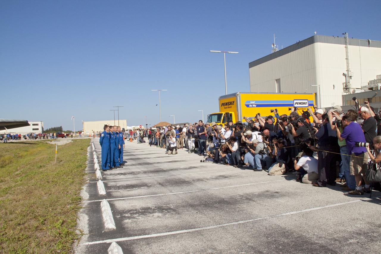 CAPE CANAVERAL, Fla. -- Members of the media and NASA Kennedy Space Center workers snap photos of the STS-135 crew members who are at the center to watch shuttle Atlantis make its final planned move from Orbiter Processing Facility-1 to the Vehicle Assembly Building. From left, are Mission Specialist Rex Walheim, Commander Chris Ferguson, Pilot Doug Hurley and Mission Specialist Sandra Magnus. The move called "rollover" is a major milestone in processing for the STS-135 mission, which will deliver the Raffaello multipurpose logistics module packed with supplies, logistics and spare parts to the International Space Station. Targeted to launch in early July, STS-135 also will fly a system to investigate the potential for robotically refueling existing spacecraft and return a failed ammonia pump module to help NASA better understand the failure mechanism and improve pump designs for future systems. Inside the VAB, the shuttle will be attached to its external fuel tank and solid rocket boosters.      STS-135 will be the 33rd flight of Atlantis, the 37th shuttle mission to the space station, and the 135th and final mission of NASA's Space Shuttle Program. For more information visit, www.nasa.gov/mission_pages/shuttle/shuttlemissions/sts135/index.html. Photo credit: NASA/Jack Pfaller