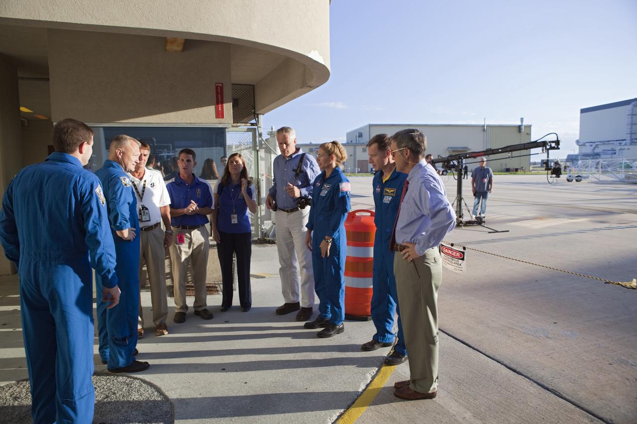 CAPE CANAVERAL, Fla. -- Kennedy Center Director Bob Cabana (right) speaks with STS-135 crew members and Kennedy employees while watching shuttle Atlantis' rollover from Orbiter Processing Facility-1 to the Vehicle Assembly Building (VAB) at NASA's Kennedy Space Center in Florida. From left are STS-135 Mission Specialist Rex Walheim, Pilot Doug Hurley, Mission Specialist Sandra Magnus and Commander Chris Ferguson.              The move called "rollover" is a major milestone in processing for the STS-135 mission to the International Space Station. Inside the VAB, the shuttle will be attached to its external fuel tank and solid rocket boosters. Commander Chris Ferguson, Pilot Doug Hurley and Mission Specialists Sandra Magnus and Rex Walheim are expected to launch in mid July, taking with them the Raffaello multipurpose logistics module packed with supplies, logistics and spare parts. The STS-135 mission also will fly a system to investigate the potential for robotically refueling existing spacecraft and return a failed ammonia pump module to help NASA better understand the failure mechanism and improve pump designs for future systems. STS-135 will be the 33rd flight of Atlantis, the 37th shuttle mission to the space station, and the 135th and final mission of NASA's Space Shuttle Program. For more information visit, www.nasa.gov/mission_pages/shuttle/shuttlemissions/sts135/index.html. Photo credit: NASA/Dimitri Gerondidakis