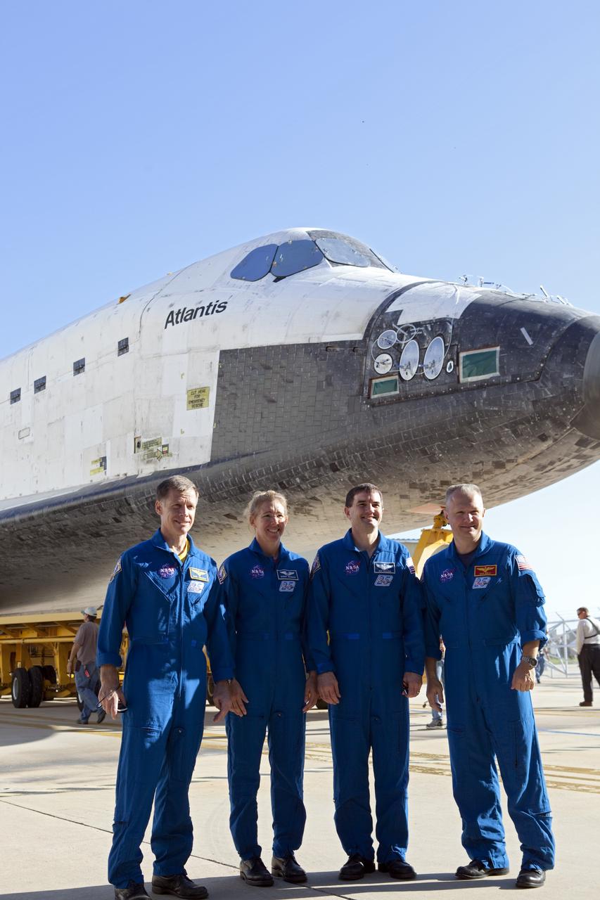 CAPE CANAVERAL, Fla. -- STS-135 Commander Chris Ferguson (left), Mission Specialists Sandra Magnus and Rex Walheim, and Pilot Doug Hurley pause for a photo while watching shuttle Atlantis' rollover from Orbiter Processing Facility-1 to the Vehicle Assembly Building (VAB) at NASA's Kennedy Space Center in Florida.        The move called "rollover" is a major milestone in processing for the STS-135 mission to the International Space Station. Inside the VAB, the shuttle will be attached to its external fuel tank and solid rocket boosters. Commander Chris Ferguson, Pilot Doug Hurley and Mission Specialists Sandra Magnus and Rex Walheim are expected to launch in mid July, taking with them the Raffaello multipurpose logistics module packed with supplies, logistics and spare parts. The STS-135 mission also will fly a system to investigate the potential for robotically refueling existing spacecraft and return a failed ammonia pump module to help NASA better understand the failure mechanism and improve pump designs for future systems. STS-135 will be the 33rd flight of Atlantis, the 37th shuttle mission to the space station, and the 135th and final mission of NASA's Space Shuttle Program. For more information visit, www.nasa.gov/mission_pages/shuttle/shuttlemissions/sts135/index.html. Photo credit: NASA/Dimitri Gerondidakis