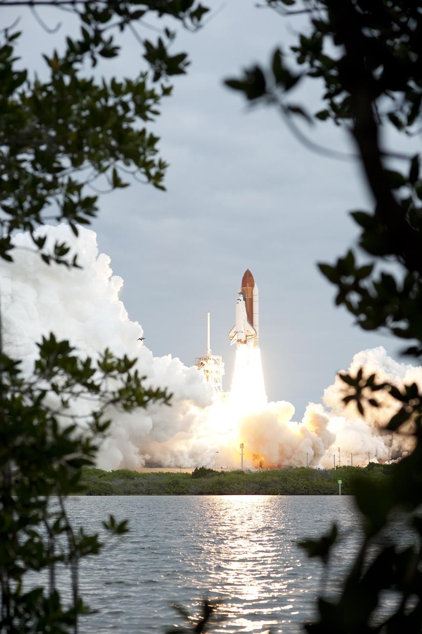 CAPE CANAVERAL, Fla. -- Seen through the foliage from across the Turn Basin, space shuttle Endeavour's solid rocket boosters roar to life at Launch Pad 39A at NASA's Kennedy Space Center in Florida.        Endeavour began its final flight, the STS-134 mission to the International Space Station, at 8:56 a.m. EDT on May 16. Endeavour and its six-member crew will deliver the Alpha Magnetic Spectrometer-2 (AMS), Express Logistics Carrier-3, a high-pressure gas tank and additional spare parts for the Dextre robotic helper to the space station. For more information visit, www.nasa.gov/mission_pages/shuttle/shuttlemissions/sts134/index.html. Photo credit: NASA/Sandra Joseph and Kevin O'Connell