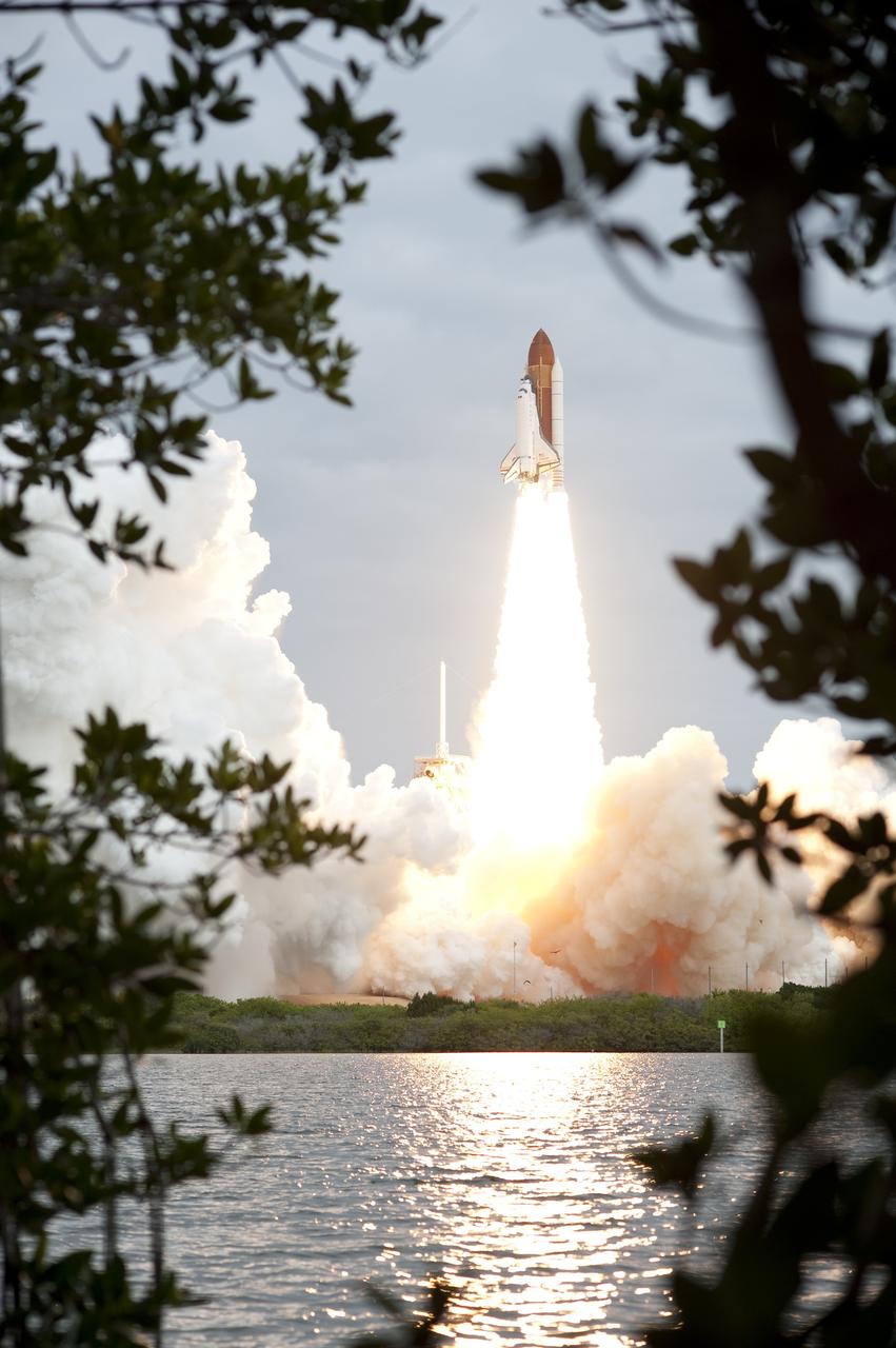 CAPE CANAVERAL, Fla. -- Seen through the foliage from across the Turn Basin, space shuttle Endeavour's solid rocket boosters roar to life at Launch Pad 39A at NASA's Kennedy Space Center in Florida.        Endeavour began its final flight, the STS-134 mission to the International Space Station, at 8:56 a.m. EDT on May 16. Endeavour and its six-member crew will deliver the Alpha Magnetic Spectrometer-2 (AMS), Express Logistics Carrier-3, a high-pressure gas tank and additional spare parts for the Dextre robotic helper to the space station. For more information visit, www.nasa.gov/mission_pages/shuttle/shuttlemissions/sts134/index.html. Photo credit: NASA/Sandra Joseph and Kevin O'Connell