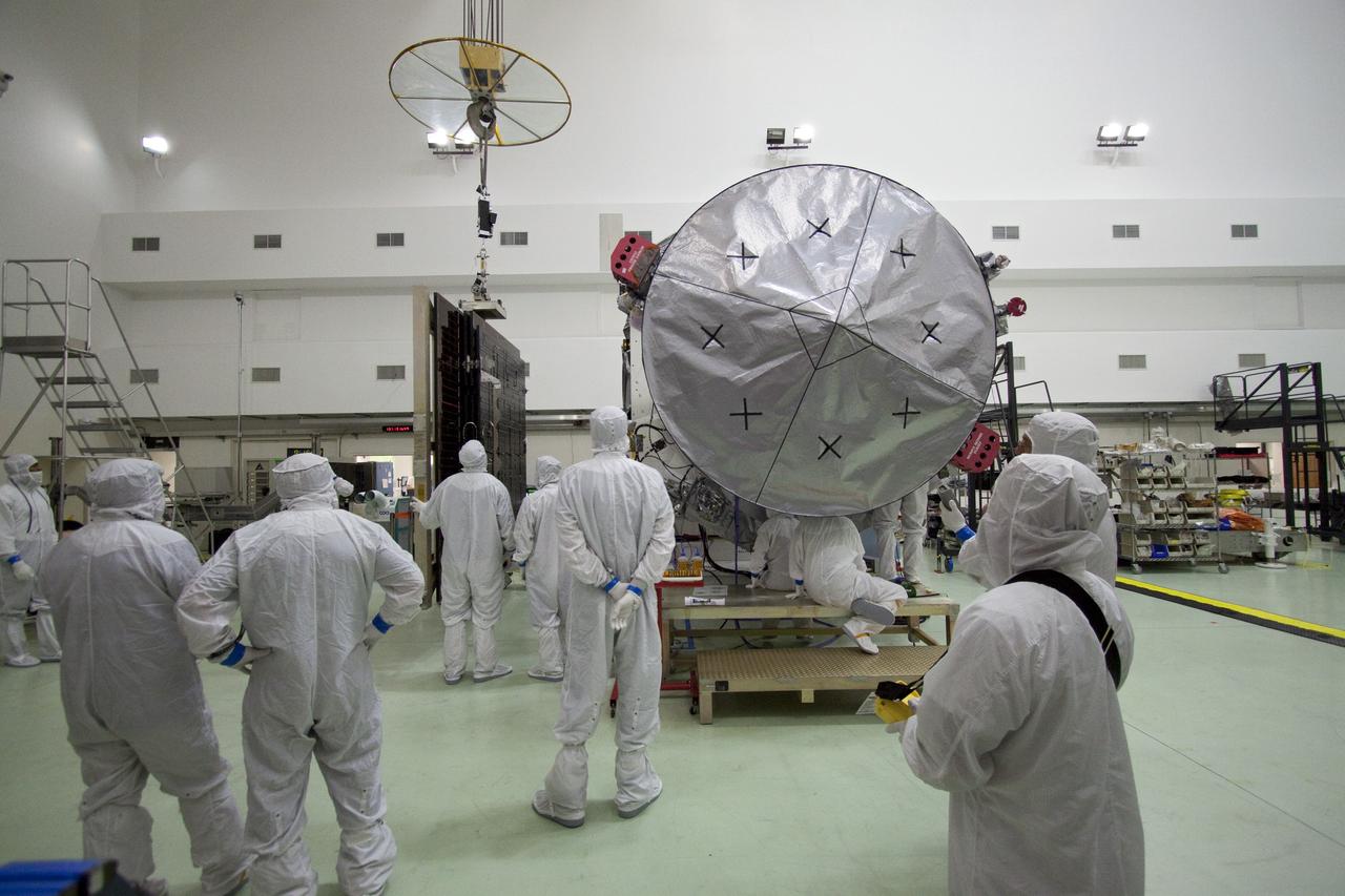 CAPE CANAVERAL, Fla. -- Technicians at Astrotech's payload processing facility in Titusville, Fla. guide the solar arrays toward NASA's Juno spacecraft for installation. Later in processing, the magnetometer will be installed; a solar array illumination and magnetometer boom deployment test also are planned.              Juno is scheduled to launch aboard an Atlas V rocket from Cape Canaveral, Fla. Aug. 5.The solar-powered spacecraft will orbit Jupiter's poles 33 times to find out more about the gas giant's origins, structure, atmosphere and magnetosphere and investigate the existence of a solid planetary core. For more information visit www.nasa.gov/juno. Photo credit: NASA/Jack Pfaller