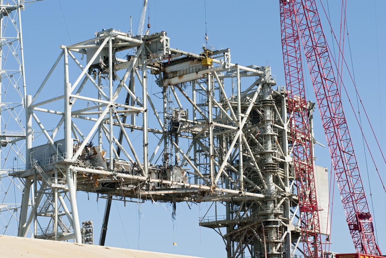 CAPE CANAVERAL, Fla. -- A large crane suspends a basket where a worker is dismantling a section of the rotating service structure on Launch Pad 39B at NASA's Kennedy Space Center in Florida. In 2009, the pad was no longer needed for the shuttle program, so it is being restructured for future use. Its new design will feature a "clean pad" for rockets to come with their own launcher, making it more versatile for a number of vehicles. The new lightning protection system, which was in place for the October 2009 launch of Ares I-X, will remain. For information on NASA's future plans, visit www.nasa.gov. Photo credit: NASA/Jim Grossmann