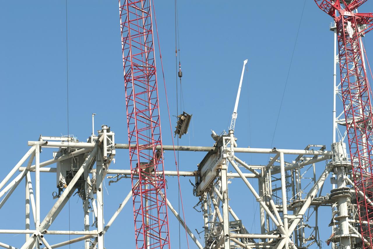 CAPE CANAVERAL, Fla. -- A large crane lowers to the ground a section of the dismantled rotating service structure on Launch Pad 39B at NASA's Kennedy Space Center in Florida. In 2009, the pad was no longer needed for the shuttle program, so it is being restructured for future use. Its new design will feature a "clean pad" for rockets to come with their own launcher, making it more versatile for a number of vehicles. The new lightning protection system, which was in place for the October 2009 launch of Ares I-X, will remain. For information on NASA's future plans, visit www.nasa.gov. Photo credit: NASA/Jim Grossmann