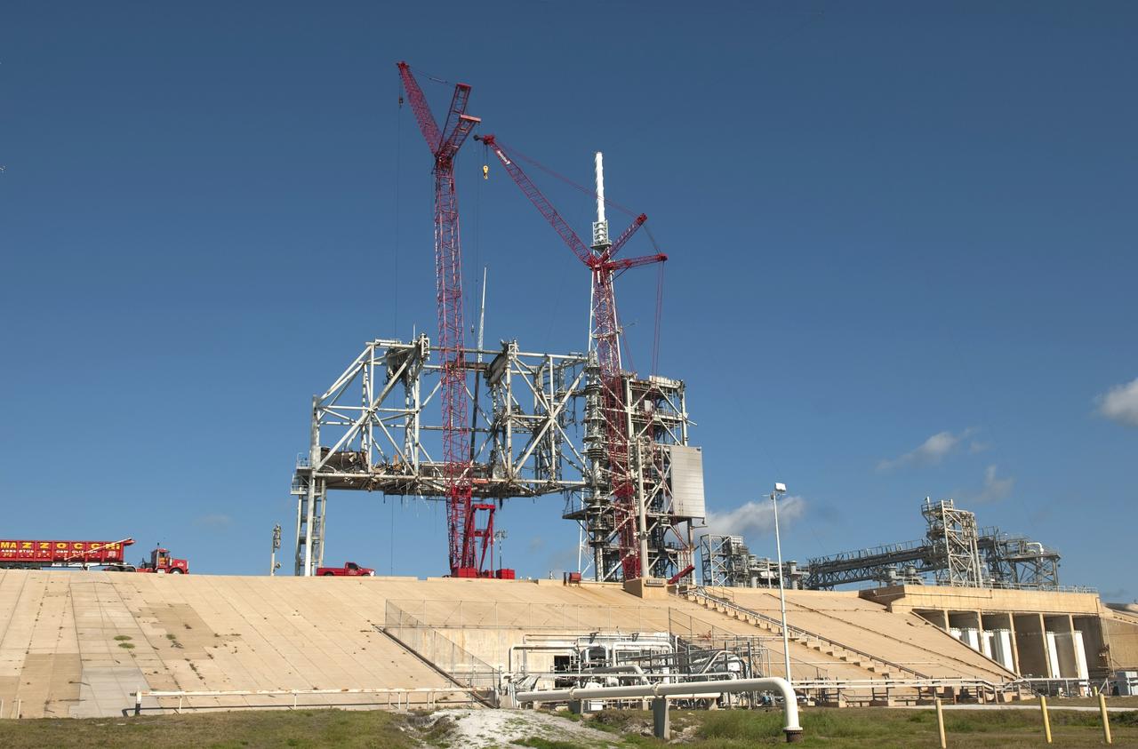 CAPE CANAVERAL, Fla. -- A large crane lowers to the ground a section of the dismantled rotating service structure on Launch Pad 39B at NASA's Kennedy Space Center in Florida. In 2009, the pad was no longer needed for the shuttle program, so it is being restructured for future use. Its new design will feature a "clean pad" for rockets to come with their own launcher, making it more versatile for a number of vehicles. The new lightning protection system, which was in place for the October 2009 launch of Ares I-X, will remain. For information on NASA's future plans, visit www.nasa.gov. Photo credit: NASA/Jim Grossmann