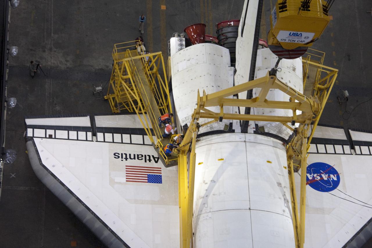 CAPE CANAVERAL, Fla. -- This overhead view photographed in the Vehicle Assembly Building at NASA's Kennedy Space Center in Florida, shows workers attaching a crane to shuttle Atlantis. The crane will lift the spacecraft into a high bay where it will be attached to the waiting external fuel tank and solid rocket boosters, which are already on the mobile launcher platform. Commander Chris Ferguson, Pilot Doug Hurley and Mission Specialists Sandra Magnus and Rex Walheim are targeted to launch in early July, taking with them the Raffaello multi-purpose logistics module packed with supplies, logistics and spare parts. The STS-135 mission also will fly a system to investigate the potential for robotically refueling existing spacecraft and return a failed ammonia pump module to help NASA better understand the failure mechanism and improve pump designs for future systems. STS-135 will be the 33rd flight of Atlantis, the 37th shuttle mission to the space station, and the 135th and final mission of NASA's Space Shuttle Program. For more information visit, www.nasa.gov/mission_pages/shuttle/shuttlemissions/sts135/index.html. Photo credit: NASA/Ken Thornsley