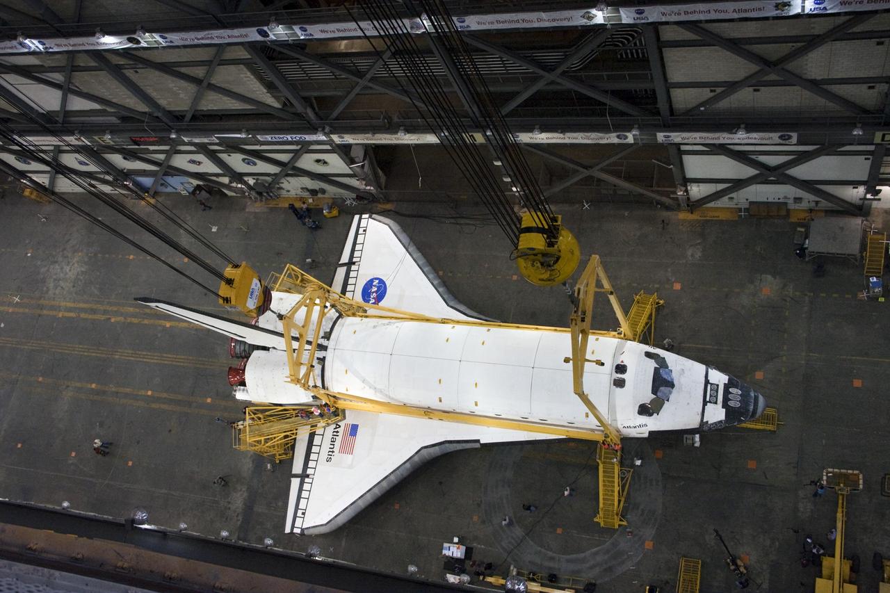 CAPE CANAVERAL, Fla. -- This overhead view photographed in the Vehicle Assembly Building at NASA's Kennedy Space Center in Florida, shows workers attaching a crane to shuttle Atlantis. The crane will lift the spacecraft into a high bay where it will be attached to the waiting external fuel tank and solid rocket boosters, which are already on the mobile launcher platform. Commander Chris Ferguson, Pilot Doug Hurley and Mission Specialists Sandra Magnus and Rex Walheim are targeted to launch in early July, taking with them the Raffaello multi-purpose logistics module packed with supplies, logistics and spare parts. The STS-135 mission also will fly a system to investigate the potential for robotically refueling existing spacecraft and return a failed ammonia pump module to help NASA better understand the failure mechanism and improve pump designs for future systems. STS-135 will be the 33rd flight of Atlantis, the 37th shuttle mission to the space station, and the 135th and final mission of NASA's Space Shuttle Program. For more information visit, www.nasa.gov/mission_pages/shuttle/shuttlemissions/sts135/index.html. Photo credit: NASA/Ken Thornsley