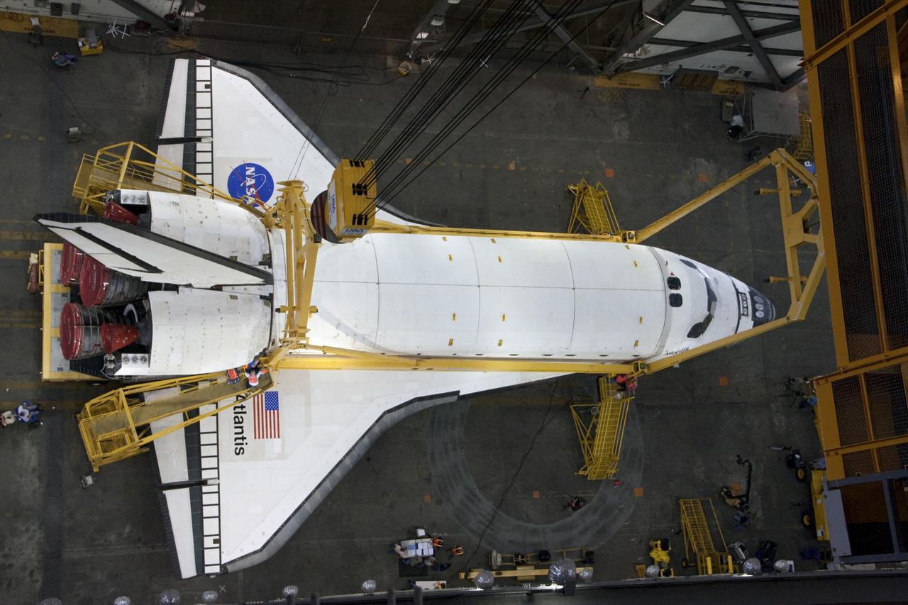 CAPE CANAVERAL, Fla. -- This overhead view photographed in the Vehicle Assembly Building at NASA's Kennedy Space Center in Florida, shows workers attaching a crane to shuttle Atlantis. The crane will lift the spacecraft into a high bay where it will be attached to the waiting external fuel tank and solid rocket boosters, which are already on the mobile launcher platform. Commander Chris Ferguson, Pilot Doug Hurley and Mission Specialists Sandra Magnus and Rex Walheim are targeted to launch in early July, taking with them the Raffaello multi-purpose logistics module packed with supplies, logistics and spare parts. The STS-135 mission also will fly a system to investigate the potential for robotically refueling existing spacecraft and return a failed ammonia pump module to help NASA better understand the failure mechanism and improve pump designs for future systems. STS-135 will be the 33rd flight of Atlantis, the 37th shuttle mission to the space station, and the 135th and final mission of NASA's Space Shuttle Program. For more information visit, www.nasa.gov/mission_pages/shuttle/shuttlemissions/sts135/index.html. Photo credit: NASA/Ken Thornsley