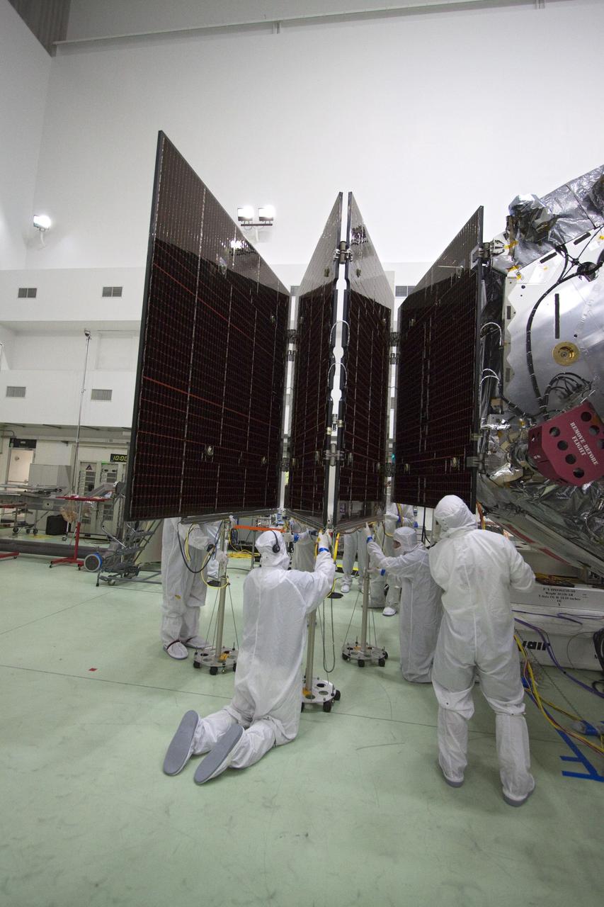 CAPE CANAVERAL, Fla. -- In a clean-room environment at Astrotech's payload processing facility in Titusville, Fla., technicians conduct deployment tests on solar array panels for NASA's Juno spacecraft prior to illumination testing.          Juno is scheduled to launch aboard a United Launch Alliance Atlas V rocket from Cape Canaveral, Fla. Aug. 5.The solar-powered spacecraft will orbit Jupiter's poles 33 times to find out more about the gas giant's origins, structure, atmosphere and magnetosphere and investigate the existence of a solid planetary core. For more information visit: www.nasa.gov/juno. Photo credit: NASA/Jack Pfaller