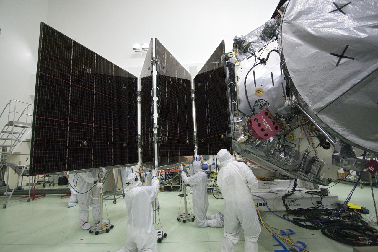 CAPE CANAVERAL, Fla. -- In a clean-room environment at Astrotech's payload processing facility in Titusville, Fla., technicians conduct deployment tests on solar array panels for NASA's Juno spacecraft prior to illumination testing.          Juno is scheduled to launch aboard a United Launch Alliance Atlas V rocket from Cape Canaveral, Fla. Aug. 5.The solar-powered spacecraft will orbit Jupiter's poles 33 times to find out more about the gas giant's origins, structure, atmosphere and magnetosphere and investigate the existence of a solid planetary core. For more information visit: www.nasa.gov/juno. Photo credit: NASA/Jack Pfaller