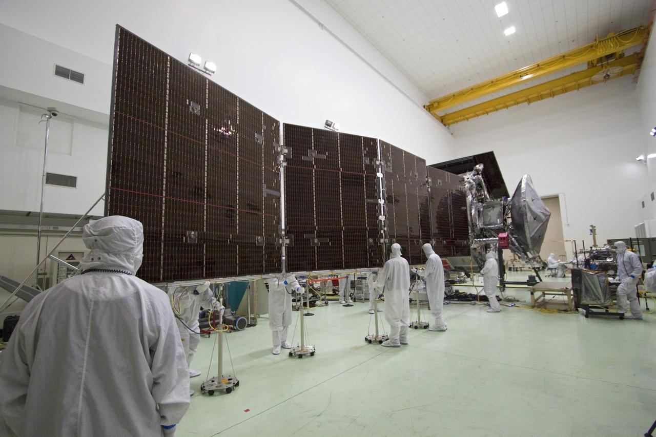 CAPE CANAVERAL, Fla. -- In a clean-room environment at Astrotech's payload processing facility in Titusville, Fla., technicians conduct deployment tests on solar array panels for NASA's Juno spacecraft prior to illumination testing.          Juno is scheduled to launch aboard a United Launch Alliance Atlas V rocket from Cape Canaveral, Fla. Aug. 5.The solar-powered spacecraft will orbit Jupiter's poles 33 times to find out more about the gas giant's origins, structure, atmosphere and magnetosphere and investigate the existence of a solid planetary core. For more information visit: www.nasa.gov/juno. Photo credit: NASA/Jack Pfaller