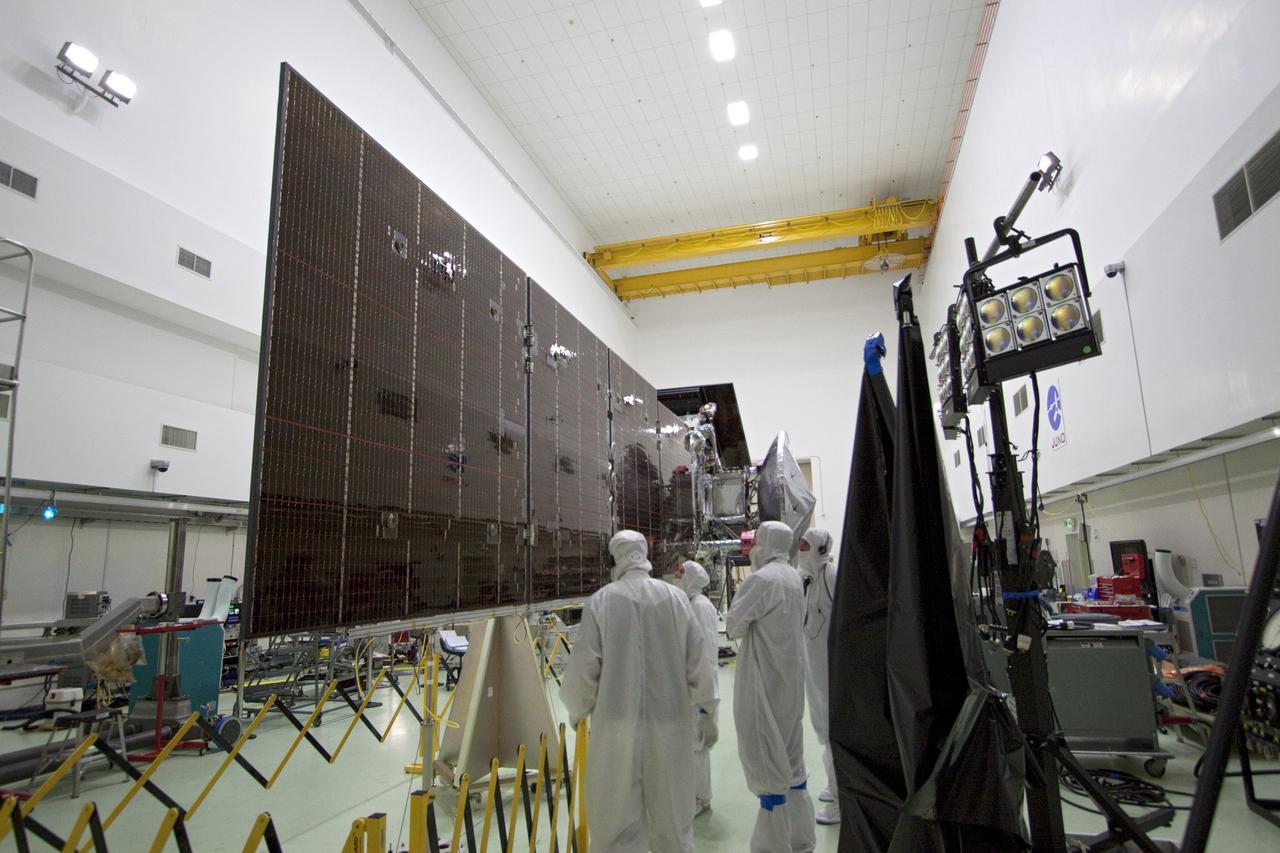 CAPE CANAVERAL, Fla. -- In a clean-room environment at Astrotech's payload processing facility in Titusville, Fla. technicians prepare solar array panels on NASA's Juno spacecraft for illumination testing.        Juno is scheduled to launch aboard a United Launch Alliance Atlas V rocket from Cape Canaveral, Fla. Aug. 5.The solar-powered spacecraft will orbit Jupiter's poles 33 times to find out more about the gas giant's origins, structure, atmosphere and magnetosphere and investigate the existence of a solid planetary core. For more information visit: www.nasa.gov/juno. Photo credit: NASA/Jack Pfaller