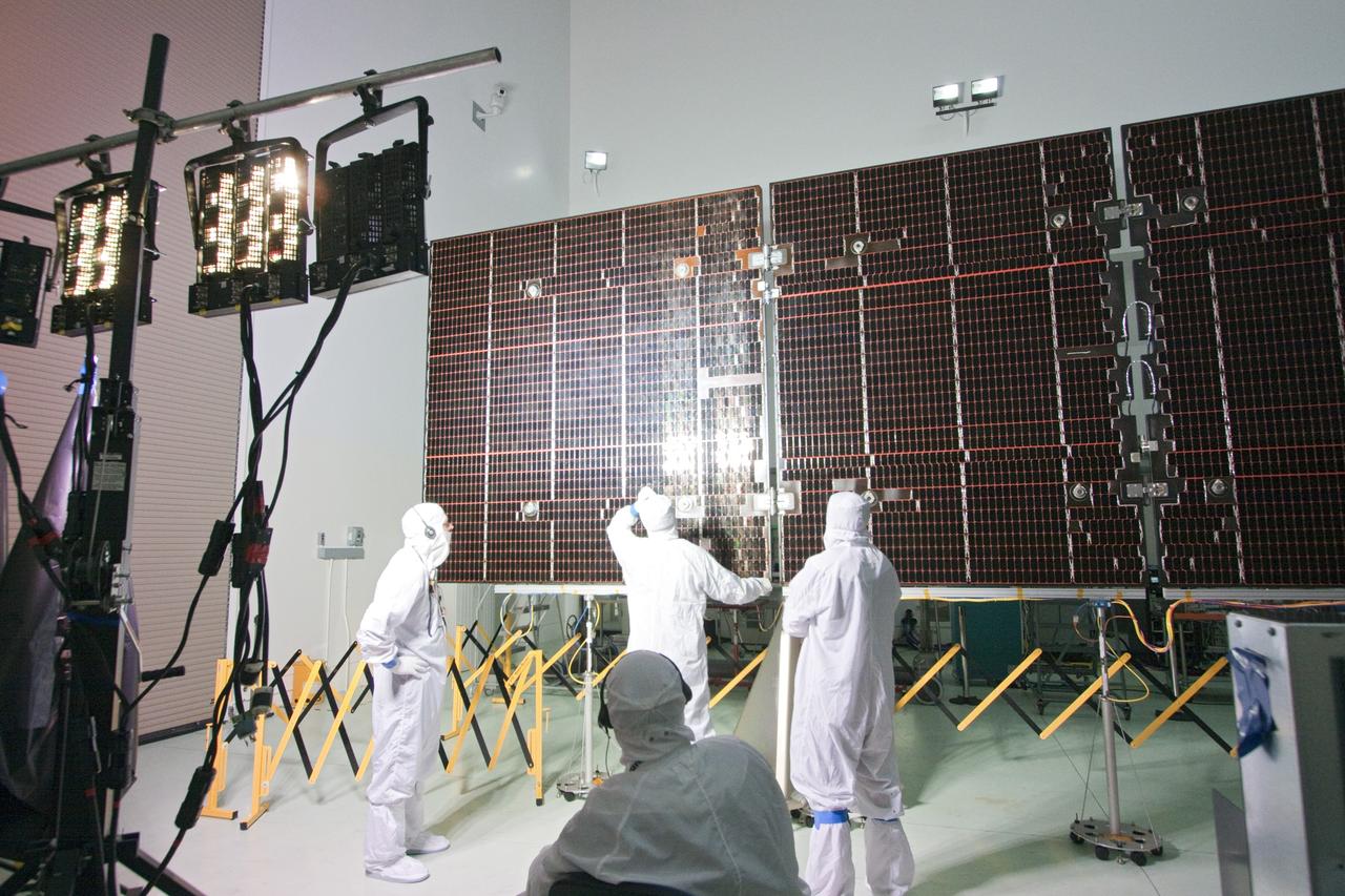 CAPE CANAVERAL, Fla. -- In a clean-room environment at Astrotech's payload processing facility in Titusville, Fla. technicians conduct an illumination test on the solar array panels for NASA's Juno spacecraft.        Juno is scheduled to launch aboard a United Launch Alliance Atlas V rocket from Cape Canaveral, Fla. Aug. 5.The solar-powered spacecraft will orbit Jupiter's poles 33 times to find out more about the gas giant's origins, structure, atmosphere and magnetosphere and investigate the existence of a solid planetary core. For more information visit: www.nasa.gov/juno. Photo credit: NASA/Jack Pfaller