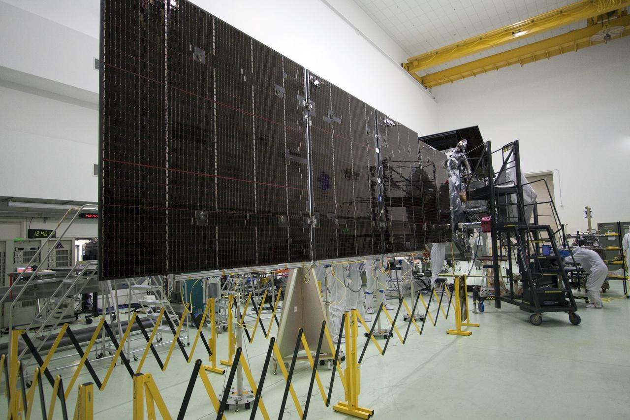 CAPE CANAVERAL, Fla. -- Technicians at Astrotech's payload processing facility in Titusville, Fla. are preparing to stow unfurled solar array #2 for NASA's Juno spacecraft. Later in processing, the magnetometer will be installed; a solar array illumination and magnetometer boom deployment test also are planned.    Juno is scheduled to launch aboard an Atlas V rocket from Cape Canaveral, Fla. Aug. 5.The solar-powered spacecraft will orbit Jupiter's poles 33 times to find out more about the gas giant's origins, structure, atmosphere and magnetosphere and investigate the existence of a solid planetary core. For more information visit, www.nasa.gov/juno. Photo credit: NASA/Jack Pfaller