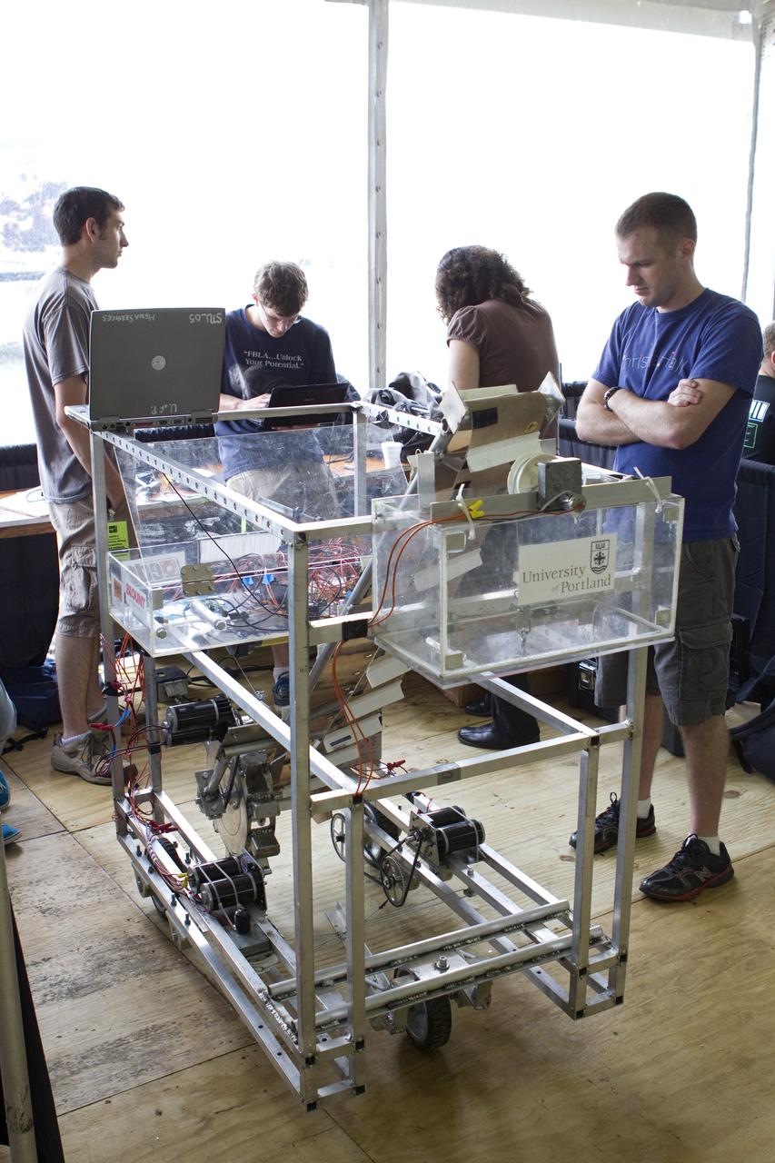 CAPE CANAVERAL, Fla. -- University students prepare for NASA's second annual Lunabotics Mining Competition at the Kennedy Space Center Visitor Complex in Florida.           Thirty-six teams of undergraduate and graduate students from the United States, Bangladesh, Canada, Colombia and India will participate in NASA's Lunabotics Mining Competition May 26 - 28. The competition is designed to engage and retain students in science, technology, engineering and mathematics (STEM). Teams will maneuver their remote controlled or autonomous excavators, called lunabots, in about 60 tons of ultra-fine simulated lunar soil, called BP-1. The competition is an Exploration Systems Mission Directorate project managed by Kennedy's Education Division. The event also provides a competitive environment that could result in innovative ideas and solutions for NASA's future excavation of the moon. Photo credit: NASA/Cory Huston