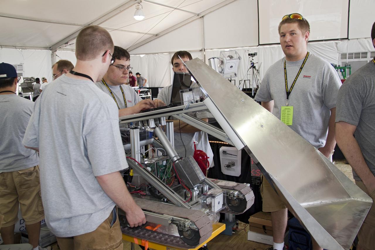 CAPE CANAVERAL, Fla. -- University students prepare for NASA's second annual Lunabotics Mining Competition at the Kennedy Space Center Visitor Complex in Florida.             Thirty-six teams of undergraduate and graduate students from the United States, Bangladesh, Canada, Colombia and India will participate in NASA's Lunabotics Mining Competition May 26 - 28 at the agency's Kennedy Space Center in Florida. The competition is designed to engage and retain students in science, technology, engineering and mathematics (STEM). Teams will maneuver their remote controlled or autonomous excavators, called lunabots, in about 60 tons of ultra-fine simulated lunar soil, called BP-1. The competition is an Exploration Systems Mission Directorate project managed by Kennedy's Education Division. The event also provides a competitive environment that could result in innovative ideas and solutions for NASA's future excavation of the moon. Photo credit: NASA/Jack Pfaller