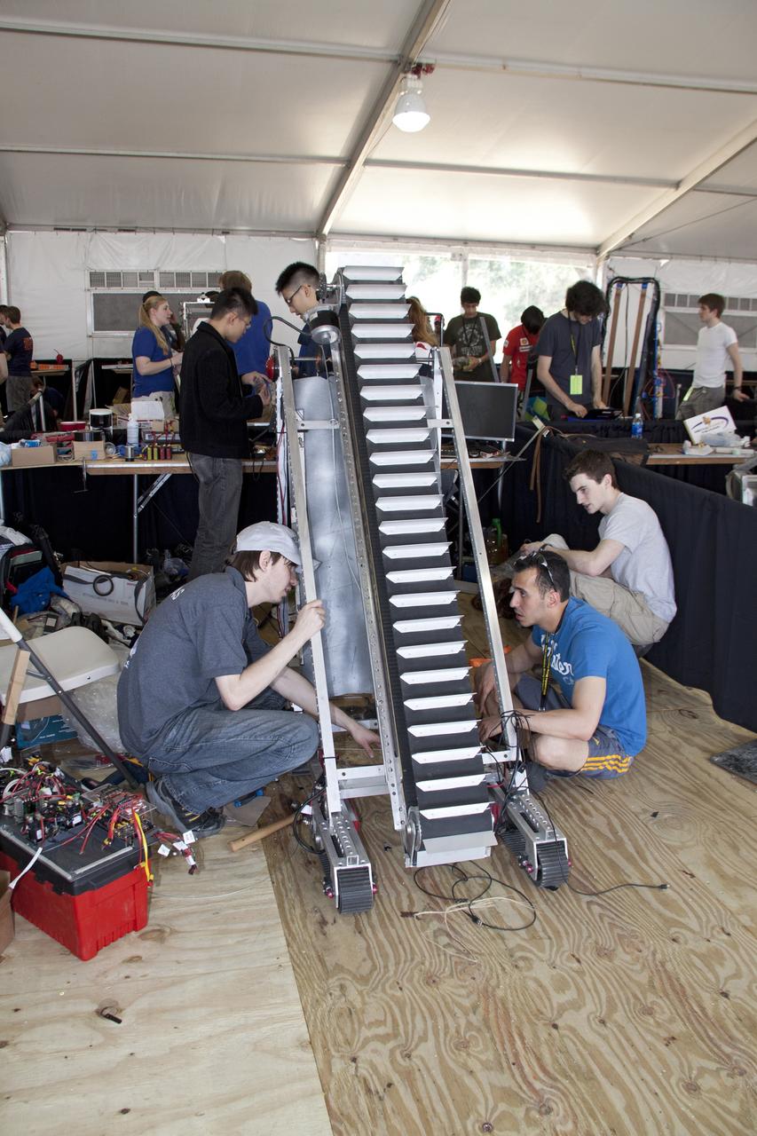 CAPE CANAVERAL, Fla. -- University students prepare for NASA's second annual Lunabotics Mining Competition at the Kennedy Space Center Visitor Complex in Florida.               Thirty-six teams of undergraduate and graduate students from the United States, Bangladesh, Canada, Colombia and India will participate in NASA's Lunabotics Mining Competition May 26 - 28 at the agency's Kennedy Space Center in Florida. The competition is designed to engage and retain students in science, technology, engineering and mathematics (STEM). Teams will maneuver their remote controlled or autonomous excavators, called lunabots, in about 60 tons of ultra-fine simulated lunar soil, called BP-1. The competition is an Exploration Systems Mission Directorate project managed by Kennedy's Education Division. The event also provides a competitive environment that could result in innovative ideas and solutions for NASA's future excavation of the moon. Photo credit: NASA/Jack Pfaller