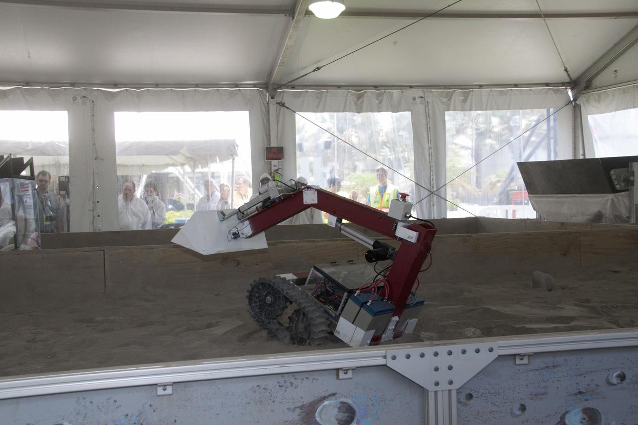 CAPE CANAVERAL, Fla. -- Inside the "Lunarena" at the Kennedy Space Center Visitor Complex is a remote controlled or autonomous excavator, called a lunabot.          Thirty-six teams of undergraduate and graduate students from the United States, Bangladesh, Canada, Colombia and India will participate in NASA's Lunabotics Mining Competition May 26 - 28 at the agency's Kennedy Space Center in Florida. The competition is designed to engage and retain students in science, technology, engineering and mathematics (STEM). Teams will maneuver their remote controlled or autonomous excavators, called lunabots, in about 60 tons of ultra-fine simulated lunar soil, called BP-1. The competition is an Exploration Systems Mission Directorate project managed by Kennedy's Education Division. The event also provides a competitive environment that could result in innovative ideas and solutions for NASA's future excavation of the moon. Photo credit: NASA/Jack Pfaller