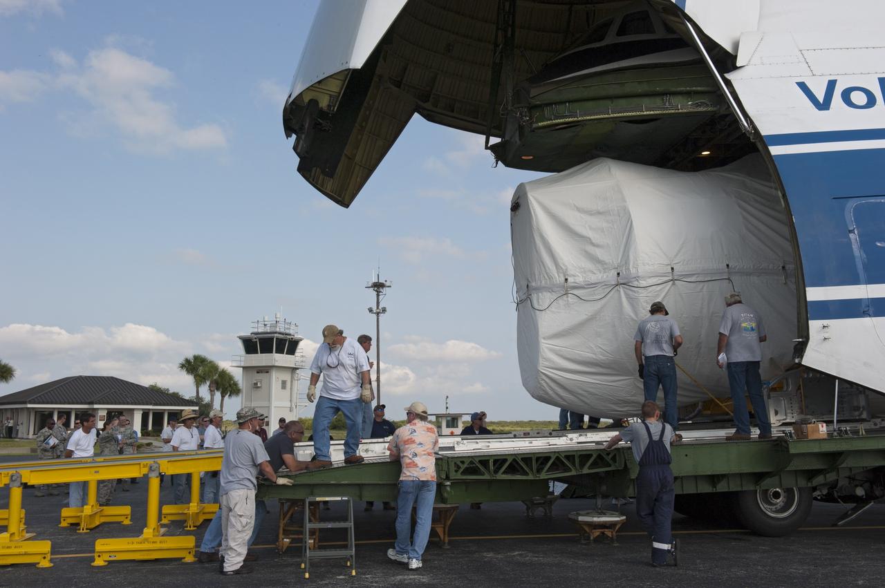 CAPE CANAVERAL, Fla. -- On the Skid Strip at Cape Canaveral Air Force Station in Florida, workers unload the first stage of the United Launch Alliance Atlas V rocket slated to launch NASA's Juno spacecraft from a Volga-Dnepr Antonov AN-124-100, a Ukranian/Russian cargo aircraft.    Juno is scheduled to launch aboard an Atlas V rocket from Cape Canaveral, Fla., Aug. 5.The solar-powered spacecraft will orbit Jupiter's poles 33 times to find out more about the gas giant's origins, structure, atmosphere and magnetosphere and investigate the existence of a solid planetary core.  For more information, visit www.nasa.gov/juno.  Photo credit: NASA/Kim Shiflett