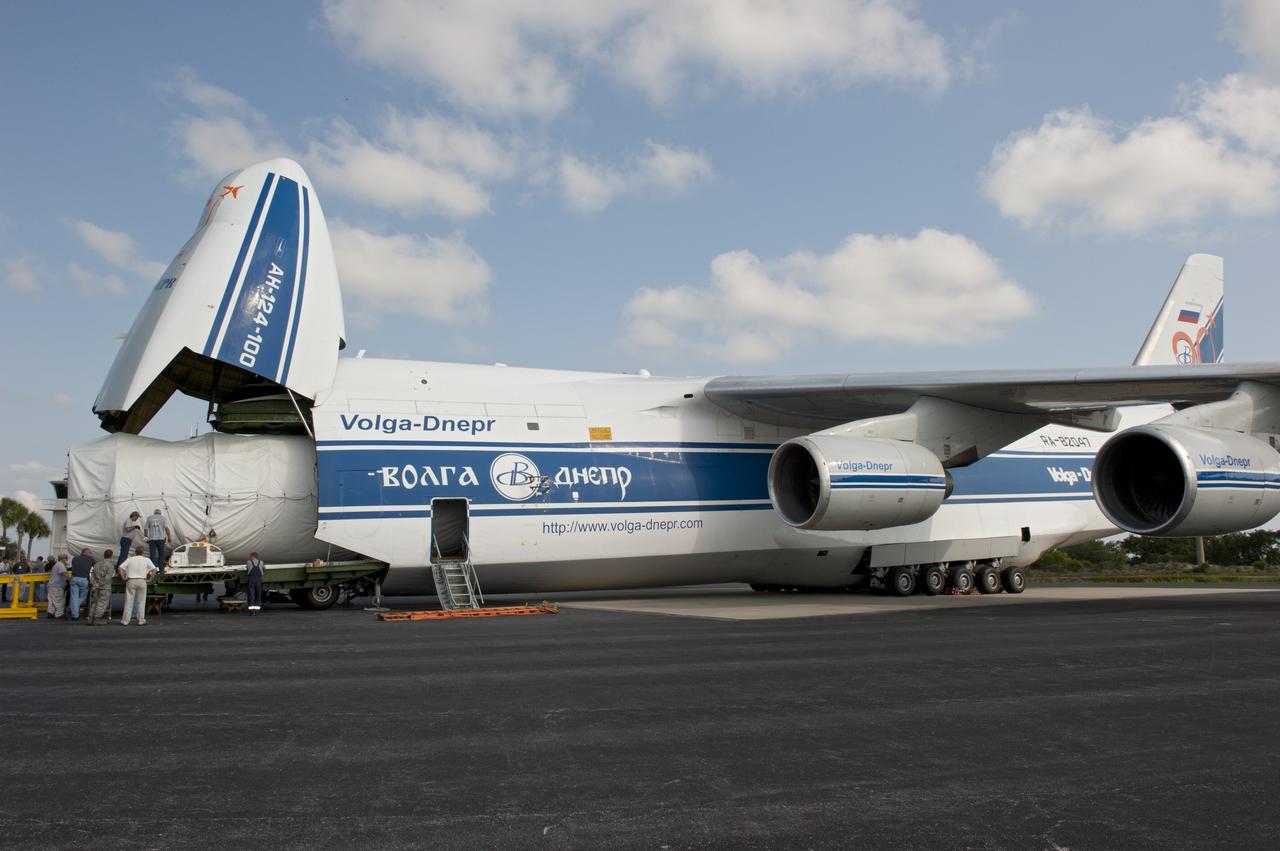 CAPE CANAVERAL, Fla. -- On the Skid Strip at Cape Canaveral Air Force Station in Florida, workers unload the first stage of the United Launch Alliance Atlas V rocket slated to launch NASA's Juno spacecraft from a Volga-Dnepr Antonov AN-124-100, a Ukranian/Russian cargo aircraft.    Juno is scheduled to launch aboard an Atlas V rocket from Cape Canaveral, Fla., Aug. 5.The solar-powered spacecraft will orbit Jupiter's poles 33 times to find out more about the gas giant's origins, structure, atmosphere and magnetosphere and investigate the existence of a solid planetary core.  For more information, visit www.nasa.gov/juno.  Photo credit: NASA/Kim Shiflett