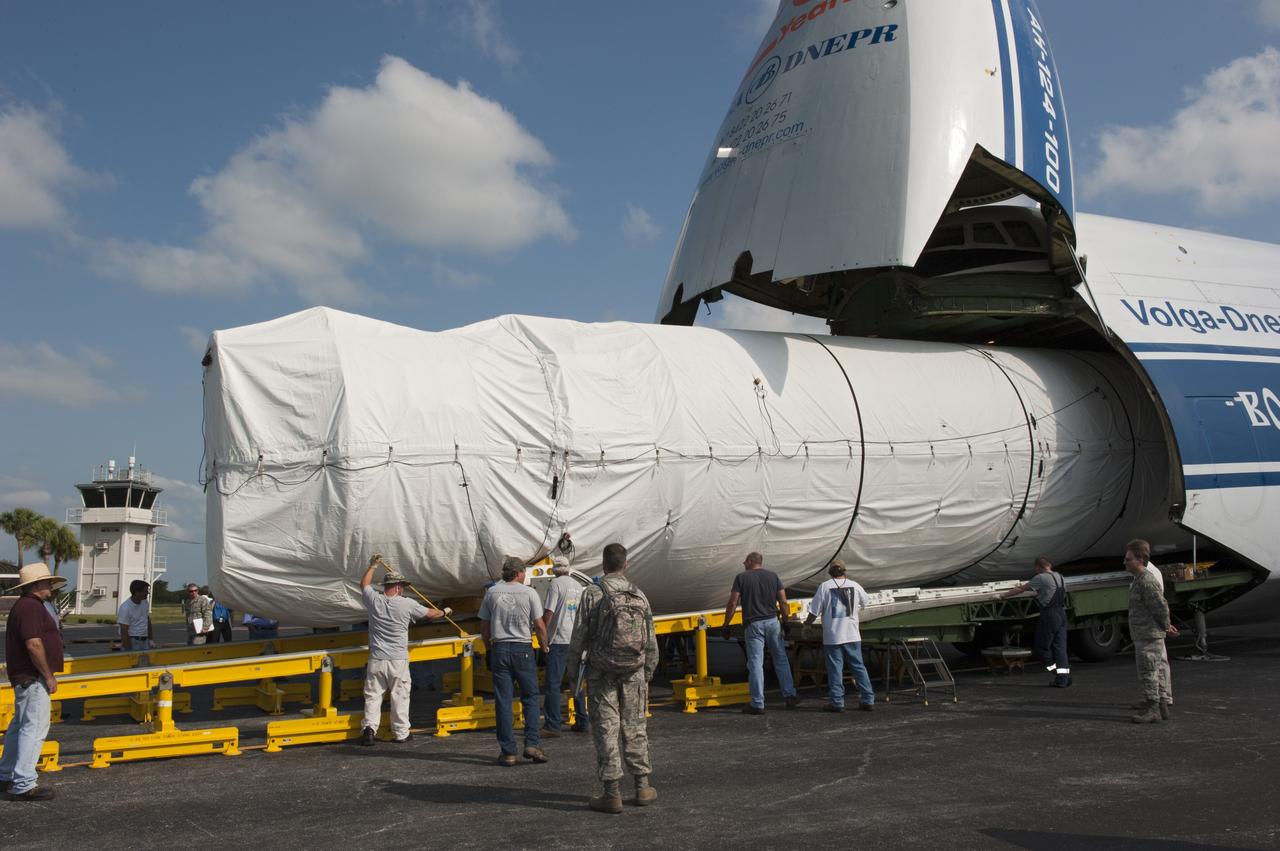 CAPE CANAVERAL, Fla. -- On the Skid Strip at Cape Canaveral Air Force Station in Florida, workers unload the first stage of the United Launch Alliance Atlas V rocket slated to launch NASA's Juno spacecraft from a Volga-Dnepr Antonov AN-124-100, a Ukranian/Russian cargo aircraft.    Juno is scheduled to launch aboard an Atlas V rocket from Cape Canaveral, Fla., Aug. 5.The solar-powered spacecraft will orbit Jupiter's poles 33 times to find out more about the gas giant's origins, structure, atmosphere and magnetosphere and investigate the existence of a solid planetary core.  For more information, visit www.nasa.gov/juno.  Photo credit: NASA/Kim Shiflett