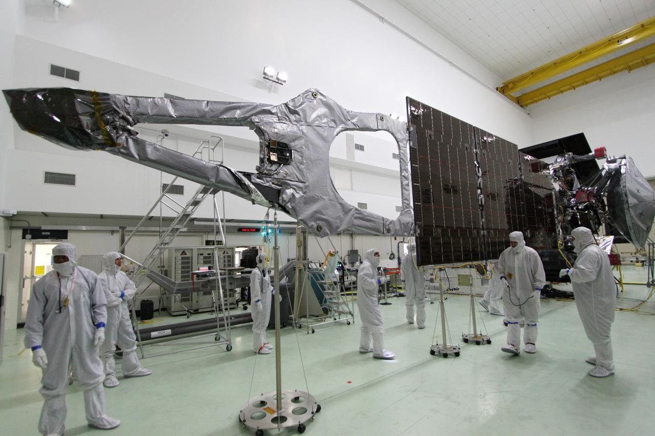 CAPE CANAVERAL, Fla. -- At Astrotech Space Operations in Titusville, Fla., technicians conduct deployment tests on solar array panel #1 with its magnetometer boom for NASA's Juno spacecraft prior to illumination testing.        Juno is scheduled to launch aboard a United Launch Alliance Atlas V from Cape Canaveral, Fla. Aug. 5.The solar-powered spacecraft will orbit Jupiter's poles 33 times to find out more about the gas giant's origins, structure, atmosphere and magnetosphere and investigate the existence of a solid planetary core. For more information visit: www.nasa.gov/juno. Photo credit: NASA/Jack Pfaller