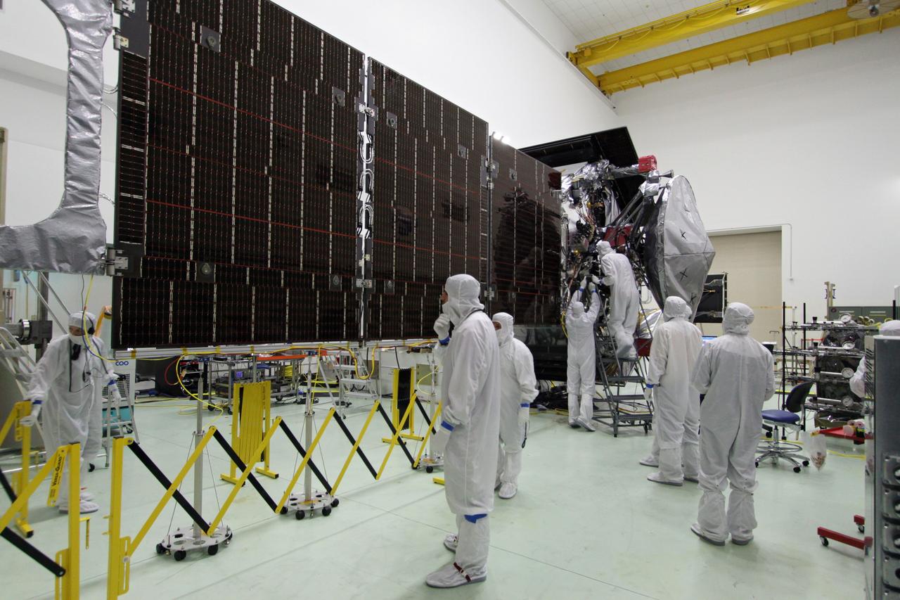 CAPE CANAVERAL, Fla. -- At Astrotech Space Operations in Titusville, Fla., technicians conduct deployment tests on solar array panel #1 with its magnetometer boom for NASA's Juno spacecraft prior to illumination testing.        Juno is scheduled to launch aboard a United Launch Alliance Atlas V from Cape Canaveral, Fla. Aug. 5.The solar-powered spacecraft will orbit Jupiter's poles 33 times to find out more about the gas giant's origins, structure, atmosphere and magnetosphere and investigate the existence of a solid planetary core. For more information visit: www.nasa.gov/juno. Photo credit: NASA/Jack Pfaller