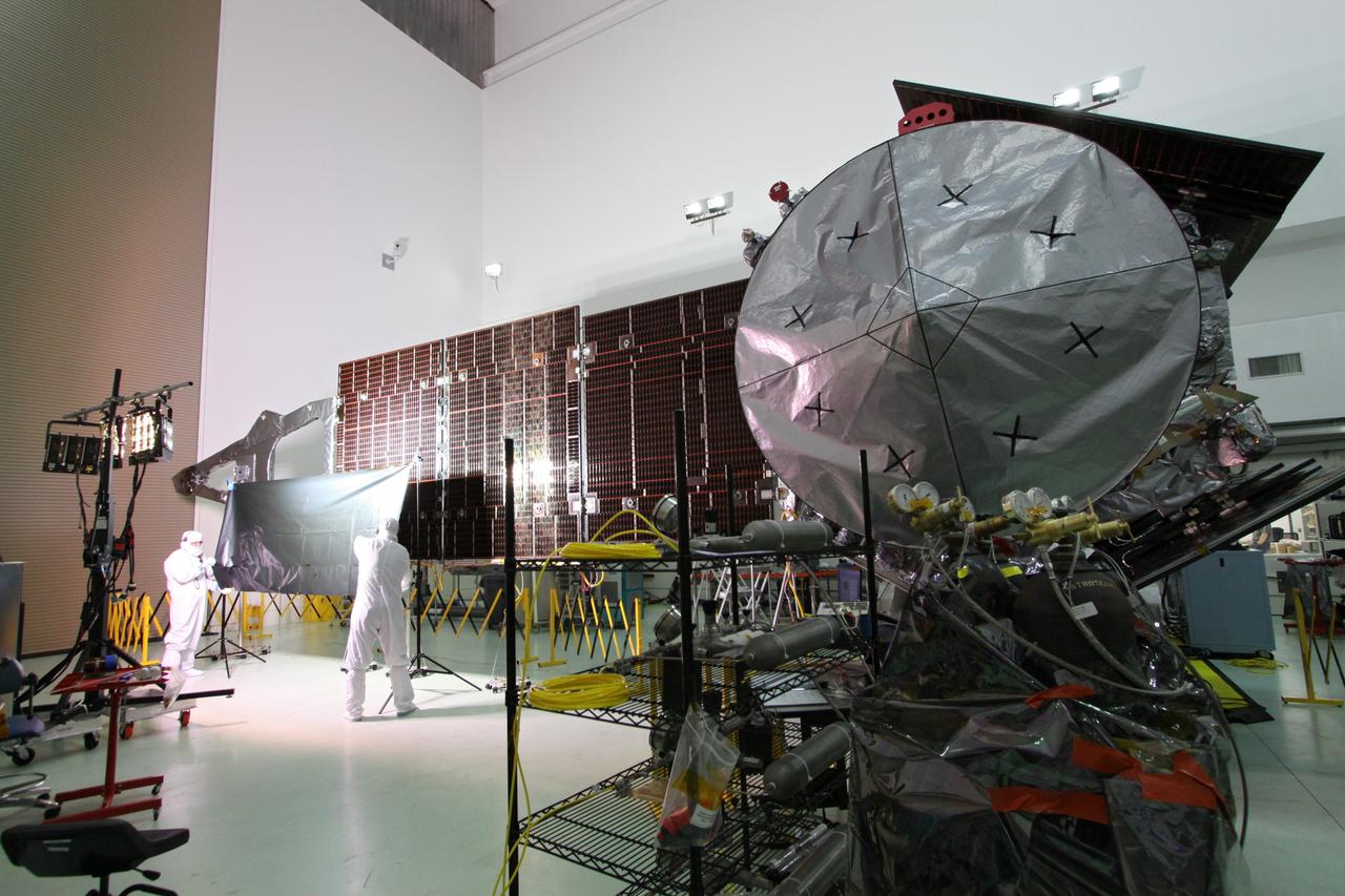 CAPE CANAVERAL, Fla. -- At Astrotech Space Operations in Titusville, Fla., technicians conduct illumination tests on solar array panel #1 with its magnetometer boom for NASA's Juno spacecraft.        Juno is scheduled to launch aboard a United Launch Alliance Atlas V from Cape Canaveral, Fla. Aug. 5.The solar-powered spacecraft will orbit Jupiter's poles 33 times to find out more about the gas giant's origins, structure, atmosphere and magnetosphere and investigate the existence of a solid planetary core. For more information visit: www.nasa.gov/juno. Photo credit: NASA/Jack Pfaller