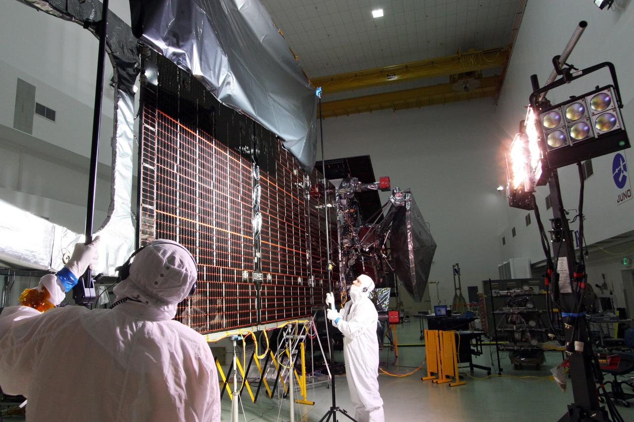 CAPE CANAVERAL, Fla. -- At Astrotech Space Operations in Titusville, Fla., technicians conduct illumination tests on solar array panel #1 with its magnetometer boom for NASA's Juno spacecraft.        Juno is scheduled to launch aboard a United Launch Alliance Atlas V from Cape Canaveral, Fla. Aug. 5.The solar-powered spacecraft will orbit Jupiter's poles 33 times to find out more about the gas giant's origins, structure, atmosphere and magnetosphere and investigate the existence of a solid planetary core. For more information visit: www.nasa.gov/juno. Photo credit: NASA/Jack Pfaller