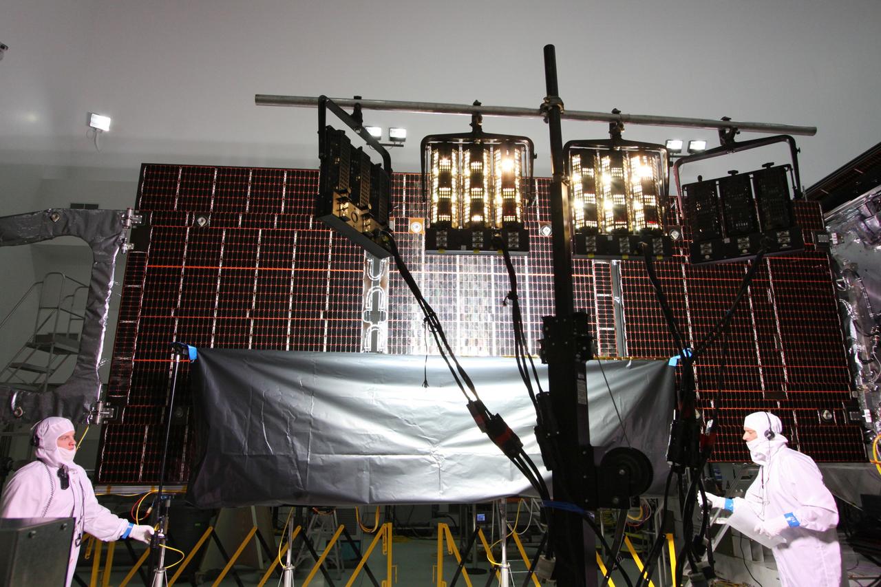 CAPE CANAVERAL, Fla. -- At Astrotech Space Operations in Titusville, Fla., technicians conduct illumination tests on solar array panel #1 with its magnetometer boom for NASA's Juno spacecraft.        Juno is scheduled to launch aboard a United Launch Alliance Atlas V from Cape Canaveral, Fla. Aug. 5.The solar-powered spacecraft will orbit Jupiter's poles 33 times to find out more about the gas giant's origins, structure, atmosphere and magnetosphere and investigate the existence of a solid planetary core. For more information visit: www.nasa.gov/juno. Photo credit: NASA/Jack Pfaller
