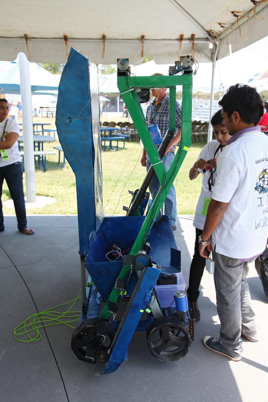 CAPE CANAVERAL, Fla. -- University students prepare their remote controlled or autonomous excavator, called a lunabot, in a tent next to the "Lunarena" at the Kennedy Space Center Visitor Complex.            Thirty-six teams of undergraduate and graduate students from the United States, Bangladesh, Canada, Colombia and India will participate in NASA's Lunabotics Mining Competition May 26 - 28 at the agency's Kennedy Space Center in Florida. The competition is designed to engage and retain students in science, technology, engineering and mathematics (STEM). Teams will maneuver their remote controlled or autonomous excavators, called lunabots, in about 60 tons of ultra-fine simulated lunar soil, called BP-1. The competition is an Exploration Systems Mission Directorate project managed by Kennedy's Education Division. The event also provides a competitive environment that could result in innovative ideas and solutions for NASA's future excavation of the moon. Photo credit: NASA/Frankie Martin