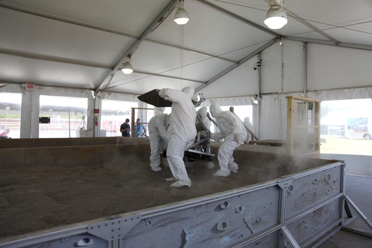 CAPE CANAVERAL, Fla. -- University students prepare for NASA's second annual Lunabotics Mining Competition inside the "Lunarena" at the Kennedy Space Center Visitor Complex in Florida.         Thirty-six teams of undergraduate and graduate students from the United States, Bangladesh, Canada, Colombia and India will participate in NASA's Lunabotics Mining Competition May 26 - 28 at the agency's Kennedy Space Center in Florida. The competition is designed to engage and retain students in science, technology, engineering and mathematics (STEM). Teams will maneuver their remote controlled or autonomous excavators, called lunabots, in about 60 tons of ultra-fine simulated lunar soil, called BP-1. The competition is an Exploration Systems Mission Directorate project managed by Kennedy's Education Division. The event also provides a competitive environment that could result in innovative ideas and solutions for NASA's future excavation of the moon. Photo credit: NASA/Frankie Martin