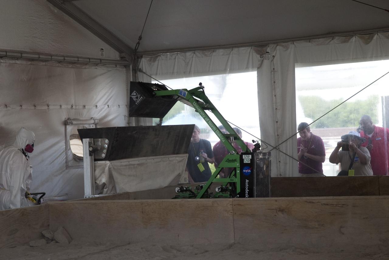 CAPE CANAVERAL, Fla. -- Inside the "Lunarena" at the Kennedy Space Center Visitor in Florida, university students maneuver their remote controlled or autonomous excavators, called lunabots, in a "sand box" of ultra-fine simulated lunar soil during NASA's second annual Lunabotics Mining Competition.            Thirty-six teams of undergraduate and graduate students from the United States, Bangladesh, Canada, Colombia and India will participate in NASA's Lunabotics Mining Competition May 26 - 28 at the agency's Kennedy Space Center in Florida. The competition is designed to engage and retain students in science, technology, engineering and mathematics (STEM). Teams will maneuver their remote controlled or autonomous excavators, called lunabots, in about 60 tons of ultra-fine simulated lunar soil, called BP-1. The competition is an Exploration Systems Mission Directorate project managed by Kennedy's Education Division. The event also provides a competitive environment that could result in innovative ideas and solutions for NASA's future excavation of the moon. Photo credit: NASA/Jim Grossmann