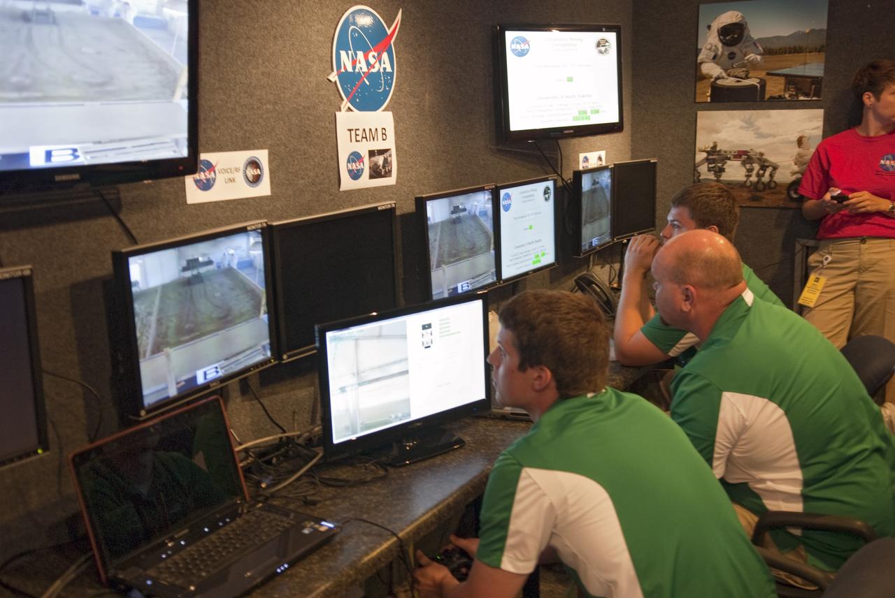 CAPE CANAVERAL, Fla. -- University students monitor their team's remote controlled or autonomous excavator, called a lunabot, as it is maneuvered in a "sand box" of ultra-fine simulated lunar soil during NASA's second annual Lunabotics Mining Competition at the Kennedy Space Center Visitor Complex in Florida.               Thirty-six teams of undergraduate and graduate students from the United States, Bangladesh, Canada, Colombia and India will participate in NASA's Lunabotics Mining Competition May 26 - 28 at the agency's Kennedy Space Center in Florida. The competition is designed to engage and retain students in science, technology, engineering and mathematics (STEM). Teams will maneuver their remote controlled or autonomous excavators, called lunabots, in about 60 tons of ultra-fine simulated lunar soil, called BP-1. The competition is an Exploration Systems Mission Directorate project managed by Kennedy's Education Division. The event also provides a competitive environment that could result in innovative ideas and solutions for NASA's future excavation of the moon. Photo credit: NASA/Jim Grossmann