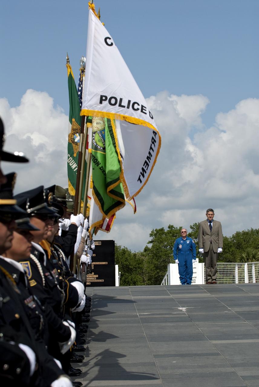 CAPE CANAVERAL, Fla. -- Kennedy Center Director Bob Cabana and Vehicle Integration Test Office and former NASA astronaut Jerry Ross walk past an honor guard as they make their way to the Astronaut Memorial Mirror at NASA's Kennedy Space Center Visitor Complex to participate in a U.S. Honor Flag presentation ceremony.             The flag will be presented to NASA to be prepared to fly aboard space shuttle Atlantis on the Space Shuttle Program's final mission, STS-135. The U.S. Honor Flag has been flown nationwide, at Ground Zero and throughout the world to honor heroes who have lost their lives while serving their community and country, including police officers, firefighters, members of the Armed Forces and astronauts. More than 100 honor guard members traveled to the Space Coast to take part in the ceremony. After the flag returns to Earth, it will continue as a traveling memorial. Photo credit: NASA/Kim Shiflett