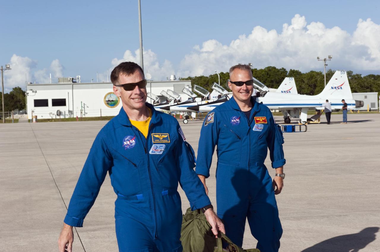 CAPE CANAVERAL, Fla. -- STS-135 Commander Chris Ferguson, left, and Pilot Doug Hurley head out on the Shuttle Landing Facility at NASA's Kennedy Space Center in Florida to practice touch-and-go landings aboard two Shuttle Training Aircraft. The flight crew of four arrived aboard T-38 training jets to watch two historic milestones of NASA's Space Shuttle Program -- the final landing of shuttle Endeavour, which will bookend its STS-134 mission to the International Space Station, and the final rollout of their vehicle, space shuttle Atlantis, to Launch Pad 39A.      STS-135 will be the 33rd flight of Atlantis, the 37th shuttle mission to the space station, and the 135th and final mission of the shuttle program. For more information visit, www.nasa.gov/mission_pages/shuttle/shuttlemissions/sts135/index.html. Photo credit: NASA/Kim Shiflett