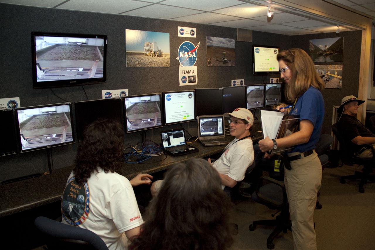 CAPE CANAVERAL, Fla. -- While an event judge looks on, university students monitor their team's remote controlled or autonomous excavator, called a lunabot, as it is maneuvered in a "sand box" of ultra-fine simulated lunar soil during NASA's second annual Lunabotics Mining Competition at the Kennedy Space Center Visitor Complex in Florida. Thirty-six teams of undergraduate and graduate students from the United States, Bangladesh, Canada, Colombia and India will participate in NASA's Lunabotics Mining Competition May 26 - 28 at the agency's Kennedy Space Center in Florida. The competition is designed to engage and retain students in science, technology, engineering and mathematics (STEM). Teams will maneuver their remote controlled or autonomous excavators, called lunabots, in about 60 tons of ultra-fine simulated lunar soil, called BP-1. The competition is an Exploration Systems Mission Directorate project managed by Kennedy's Education Division. The event also provides a competitive environment that could result in innovative ideas and solutions for NASA's future excavation of the moon. Photo credit: NASA/Jack Pfaller