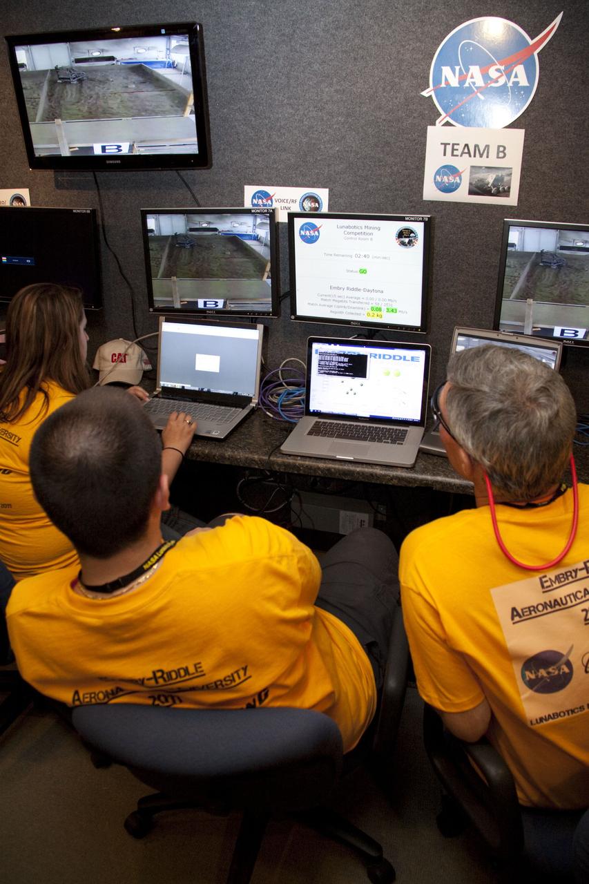 CAPE CANAVERAL, Fla. -- University students monitor their team's remote controlled or autonomous excavator, called a lunabot, as it is maneuvered in a "sand box" of ultra-fine simulated lunar soil during NASA's second annual Lunabotics Mining Competition at the Kennedy Space Center Visitor Complex in Florida.          Thirty-six teams of undergraduate and graduate students from the United States, Bangladesh, Canada, Colombia and India will participate in NASA's Lunabotics Mining Competition May 26 - 28 at the agency's Kennedy Space Center in Florida. The competition is designed to engage and retain students in science, technology, engineering and mathematics (STEM). Teams will maneuver their remote controlled or autonomous excavators, called lunabots, in about 60 tons of ultra-fine simulated lunar soil, called BP-1. The competition is an Exploration Systems Mission Directorate project managed by Kennedy's Education Division. The event also provides a competitive environment that could result in innovative ideas and solutions for NASA's future excavation of the moon. Photo credit: NASA/Jack Pfaller