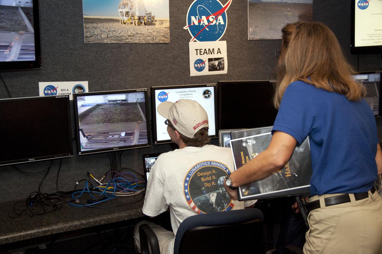 CAPE CANAVERAL, Fla. -- University students monitor their team's remote controlled or autonomous excavator, called a lunabot, as it is maneuvered in a "sand box" of ultra-fine simulated lunar soil during NASA's second annual Lunabotics Mining Competition at the Kennedy Space Center Visitor Complex in Florida.          Thirty-six teams of undergraduate and graduate students from the United States, Bangladesh, Canada, Colombia and India will participate in NASA's Lunabotics Mining Competition May 26 - 28 at the agency's Kennedy Space Center in Florida. The competition is designed to engage and retain students in science, technology, engineering and mathematics (STEM). Teams will maneuver their remote controlled or autonomous excavators, called lunabots, in about 60 tons of ultra-fine simulated lunar soil, called BP-1. The competition is an Exploration Systems Mission Directorate project managed by Kennedy's Education Division. The event also provides a competitive environment that could result in innovative ideas and solutions for NASA's future excavation of the moon. Photo credit: NASA/Jack Pfaller