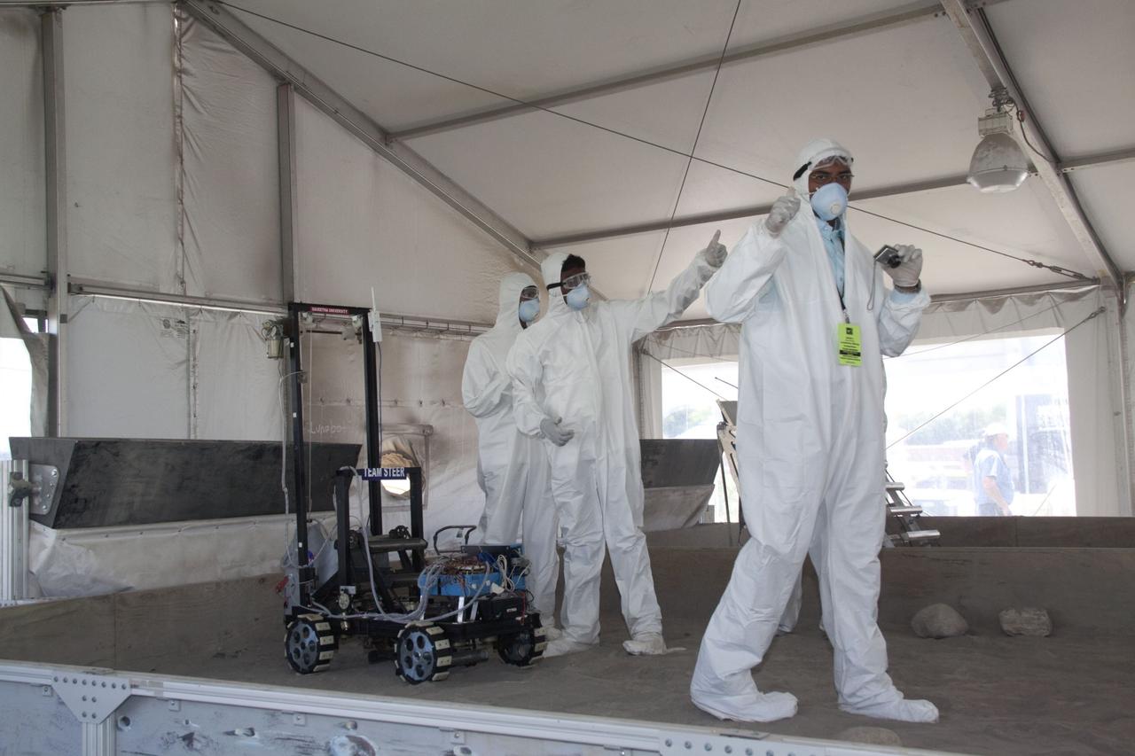 CAPE CANAVERAL, Fla. -- Inside the "Lunarena" at the Kennedy Space Center Visitor Complex in Florida, university students give their "thumbs up" after maneuvering their remote controlled or autonomous excavators, called lunabots, in a "sand box" of ultra-fine simulated lunar soil during NASA's second annual Lunabotics Mining Competition. Thirty-six teams of undergraduate and graduate students from the United States, Bangladesh, Canada, Colombia and India will participate in NASA's Lunabotics Mining Competition May 26 - 28 at the agency's Kennedy Space Center in Florida. The competition is designed to engage and retain students in science, technology, engineering and mathematics (STEM). Teams will maneuver their remote controlled or autonomous excavators, called lunabots, in about 60 tons of ultra-fine simulated lunar soil, called BP-1. The competition is an Exploration Systems Mission Directorate project managed by Kennedy's Education Division. The event also provides a competitive environment that could result in innovative ideas and solutions for NASA's future excavation of the moon. Photo credit: NASA/Jack Pfaller