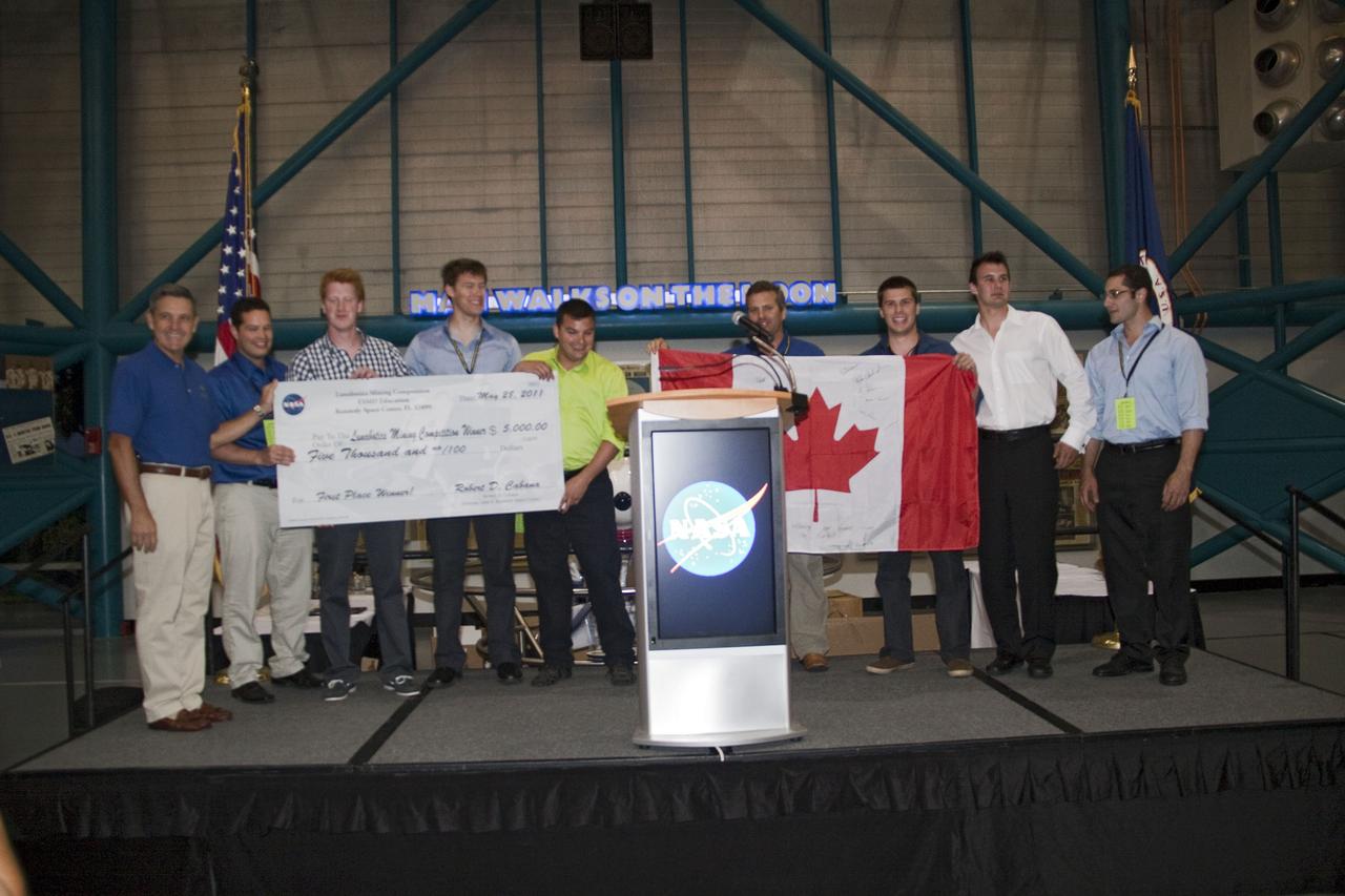 CAPE CANAVERAL, Fla. -- At NASA Kennedy Space Center's Apollo/Saturn V Center, the Laurentian University Team from Ontario, accepts a check for its "lunabot," which came in first place at NASA's second annual Lunabotics Mining Competition.       Thirty-six teams of undergraduate and graduate students from the United States, Bangladesh, Canada, Colombia and India participated in NASA's Lunabotics Mining Competition May 26 - 28 at the agency's Kennedy Space Center in Florida. The competition is designed to engage and retain students in science, technology, engineering and mathematics (STEM). Teams will maneuver their remote controlled or autonomous excavators, called lunabots, in about 60 tons of ultra-fine simulated lunar soil, called BP-1. The competition is an Exploration Systems Mission Directorate project managed by Kennedy's Education Division. The event also provides a competitive environment that could result in innovative ideas and solutions for NASA's future excavation of the moon. Photo credit: NASA/Jack Pfaller