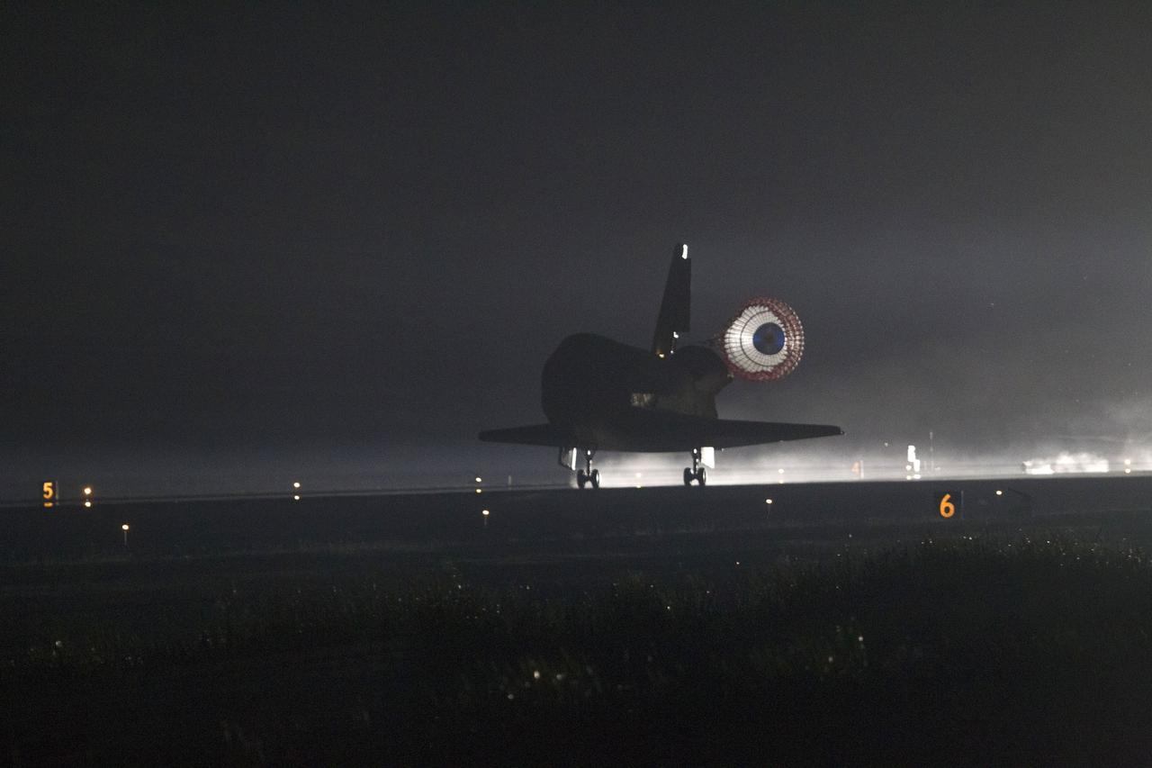 CAPE CANAVERAL, Fla. -- Xenon lights illuminate space shuttle Endeavour's unfurled drag chute as the vehicle rolls to a stop on the Shuttle Landing Facility's Runway 15 at NASA's Kennedy Space Center in Florida for the final time. Main gear touchdown was at 2:34:51 a.m. EDT, followed by nose gear touchdown at 2:35:04 a.m., and wheelstop at 2:35:36 a.m. On board are STS-134 Commander Mark Kelly, Pilot Greg H. Johnson, and Mission Specialists Mike Fincke, Drew Feustel, Greg Chamitoff and the European Space Agency's Roberto Vittori.      STS-134 delivered the Alpha Magnetic Spectrometer-2 (AMS) and the Express Logistics Carrier-3 (ELC-3) to the International Space Station. AMS will help researchers understand the origin of the universe and search for evidence of dark matter, strange matter and antimatter from the station. ELC-3 carried spare parts that will sustain station operations once the shuttles are retired from service. STS-134 was the 25th and final flight for Endeavour, which has spent 299 days in space, orbited Earth 4,671 times and traveled 122,883,151 miles. Photo credit: NASA/Tony Gray