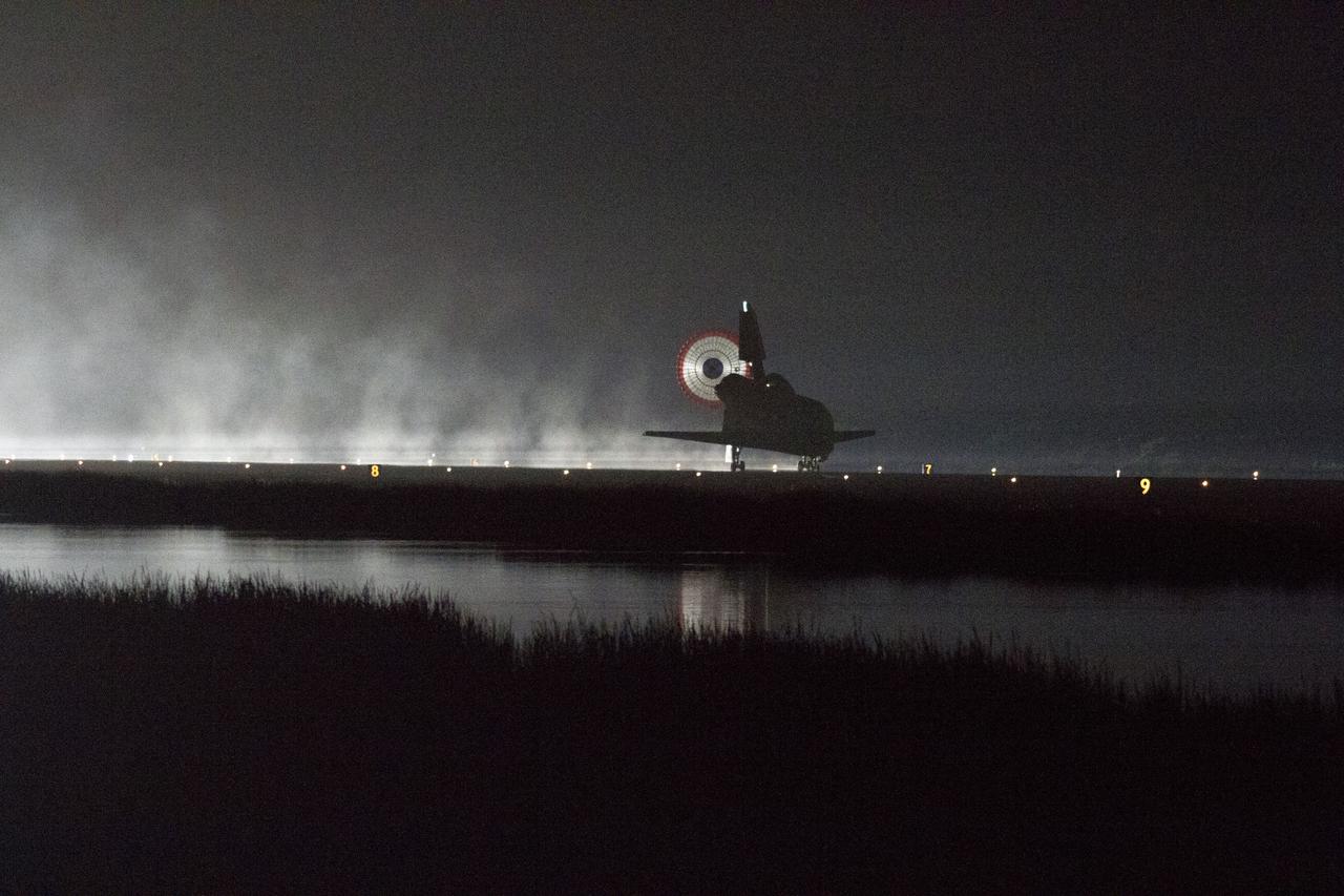 CAPE CANAVERAL, Fla. -- Xenon lights illuminate space shuttle Endeavour's unfurled drag chute as the vehicle rolls to a stop on the Shuttle Landing Facility's Runway 15 at NASA's Kennedy Space Center in Florida for the final time. Main gear touchdown was at 2:34:51 a.m. EDT, followed by nose gear touchdown at 2:35:04 a.m., and wheelstop at 2:35:36 a.m. On board are STS-134 Commander Mark Kelly, Pilot Greg H. Johnson, and Mission Specialists Mike Fincke, Drew Feustel, Greg Chamitoff and the European Space Agency's Roberto Vittori. STS-134 delivered the Alpha Magnetic Spectrometer-2 (AMS) and the Express Logistics Carrier-3 (ELC-3) to the International Space Station. AMS will help researchers understand the origin of the universe and search for evidence of dark matter, strange matter and antimatter from the station. ELC-3 carried spare parts that will sustain station operations once the shuttles are retired from service. STS-134 was the 25th and final flight for Endeavour, which has spent 299 days in space, orbited Earth 4,671 times and traveled 122,883,151 miles. Photo credit: NASA/Kenny Allen