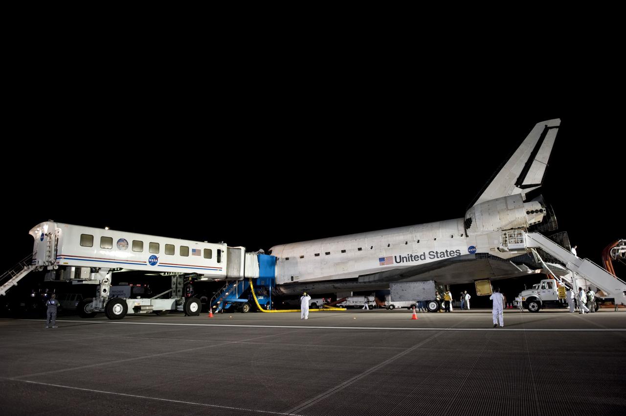 CAPE CANAVERAL, Fla. -- The landing convoy that will make space shuttle Endeavour safe and secure for towing to its processing hangar begins to pull up around the vehicle following wheelstop on the Shuttle Landing Facility's Runway 15 at NASA's Kennedy Space Center in Florida. Endeavour's final return from space completed the 16-day, 6.5-million-mile STS-134 mission. Main gear touchdown was at 2:34:51 a.m. EDT, followed by nose gear touchdown at 2:35:04 a.m., and wheelstop at 2:35:36 a.m.  STS-134 delivered the Alpha Magnetic Spectrometer-2 (AMS) and the Express Logistics Carrier-3 (ELC-3) to the International Space Station. AMS will help researchers understand the origin of the universe and search for evidence of dark matter, strange matter and antimatter from the station. ELC-3 carried spare parts that will sustain station operations once the shuttles are retired from service. STS-134 was the 25th and final flight for Endeavour, which spent 299 days in space, orbited Earth 4,671 times and traveled 122,883,151 miles. Photo credit: NASA/Kim Shiflett