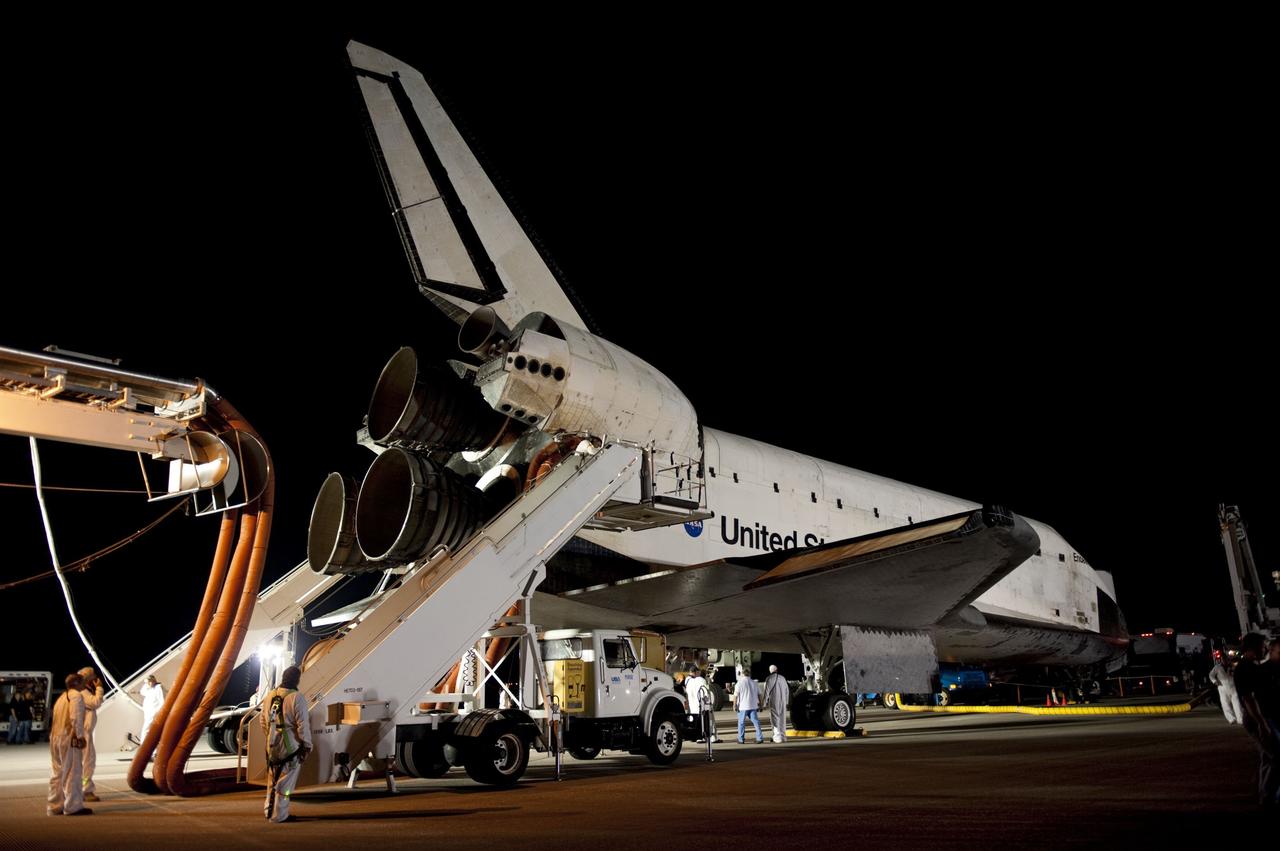 CAPE CANAVERAL, Fla. -- The landing convoy that will make space shuttle Endeavour safe and secure for towing to its processing hangar begins to pull up around the vehicle following wheelstop on the Shuttle Landing Facility's Runway 15 at NASA's Kennedy Space Center in Florida. Endeavour's final return from space completed the 16-day, 6.5-million-mile STS-134 mission. Main gear touchdown was at 2:34:51 a.m. EDT, followed by nose gear touchdown at 2:35:04 a.m., and wheelstop at 2:35:36 a.m.  STS-134 delivered the Alpha Magnetic Spectrometer-2 (AMS) and the Express Logistics Carrier-3 (ELC-3) to the International Space Station. AMS will help researchers understand the origin of the universe and search for evidence of dark matter, strange matter and antimatter from the station. ELC-3 carried spare parts that will sustain station operations once the shuttles are retired from service. STS-134 was the 25th and final flight for Endeavour, which spent 299 days in space, orbited Earth 4,671 times and traveled 122,883,151 miles. Photo credit: NASA/Kim Shiflett